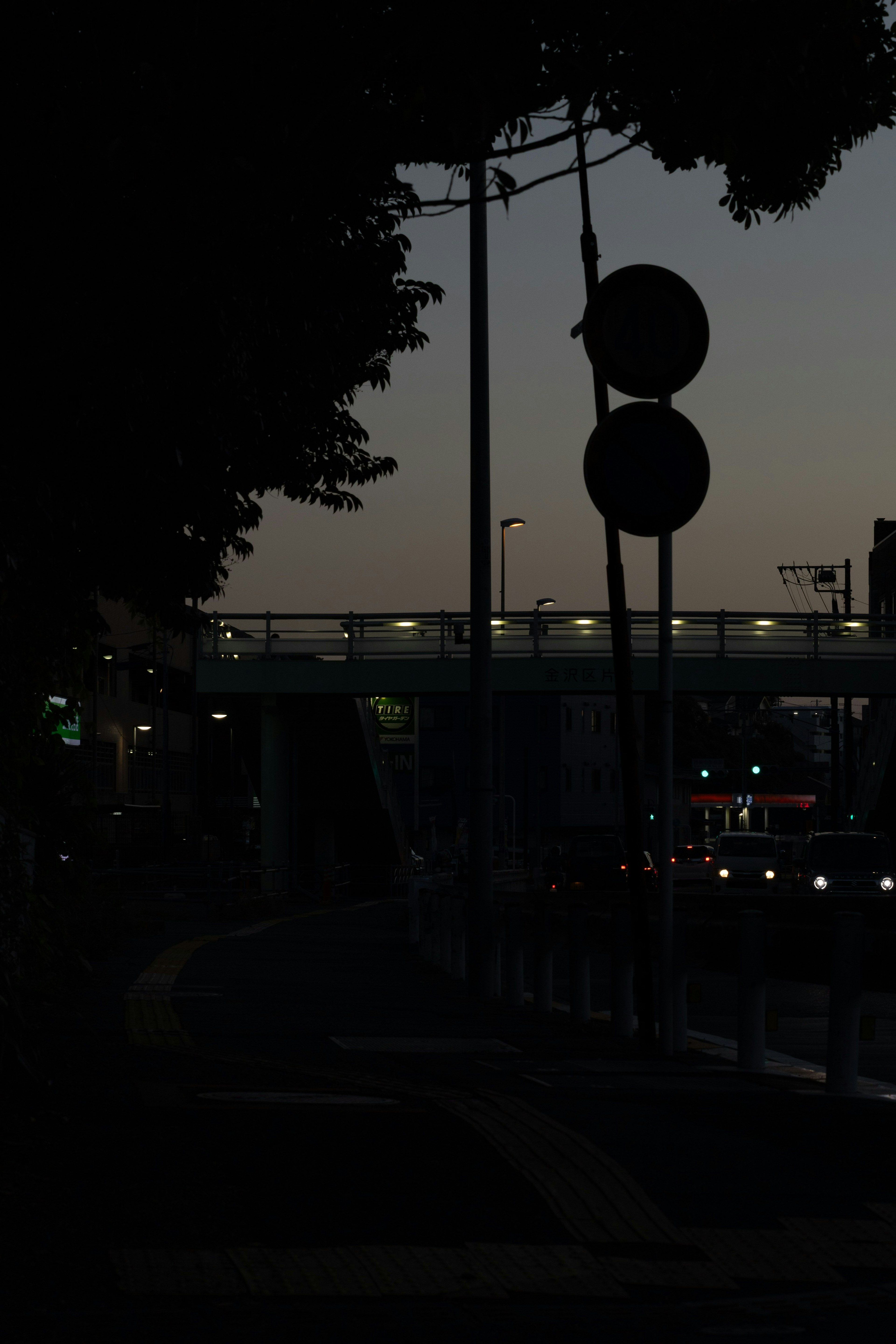 薄暗い街道に立つ信号機と街灯のシルエット 夜の都市の雰囲気