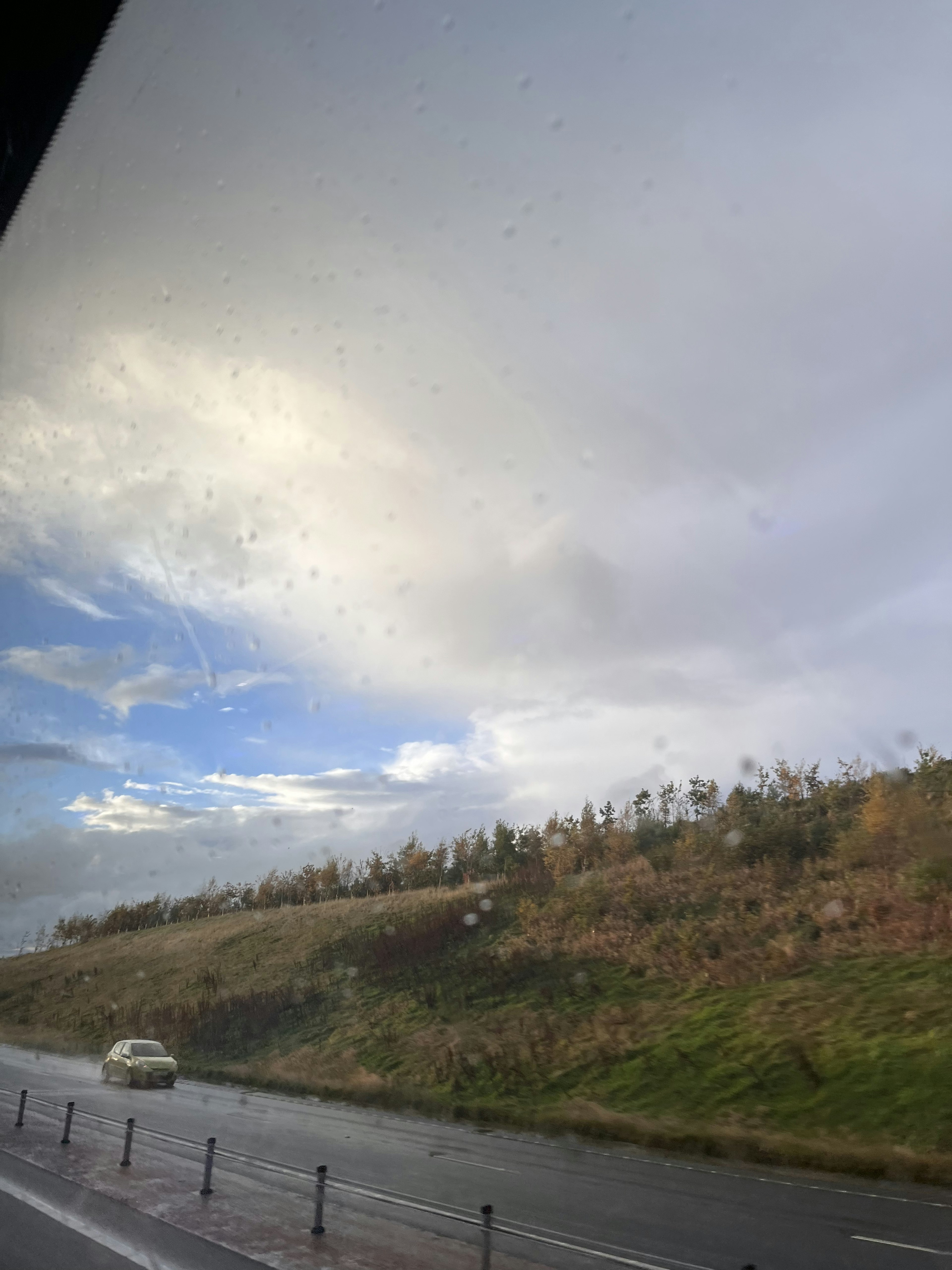 青空と雲が広がる風景に沿った道路と丘