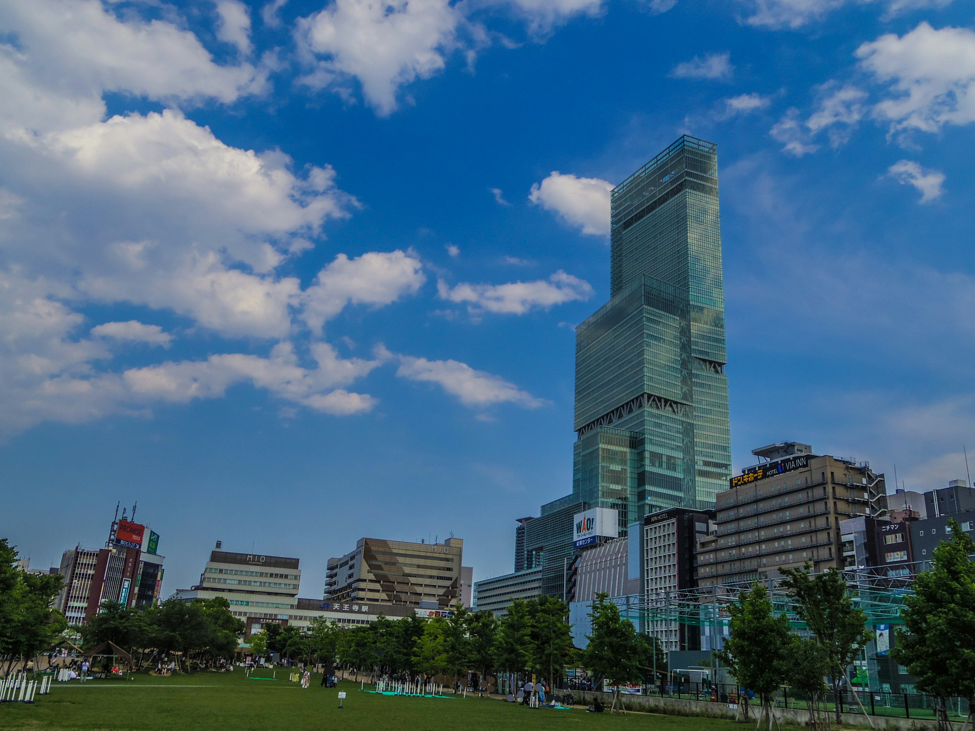 City skyline featuring a tall modern building under a blue sky