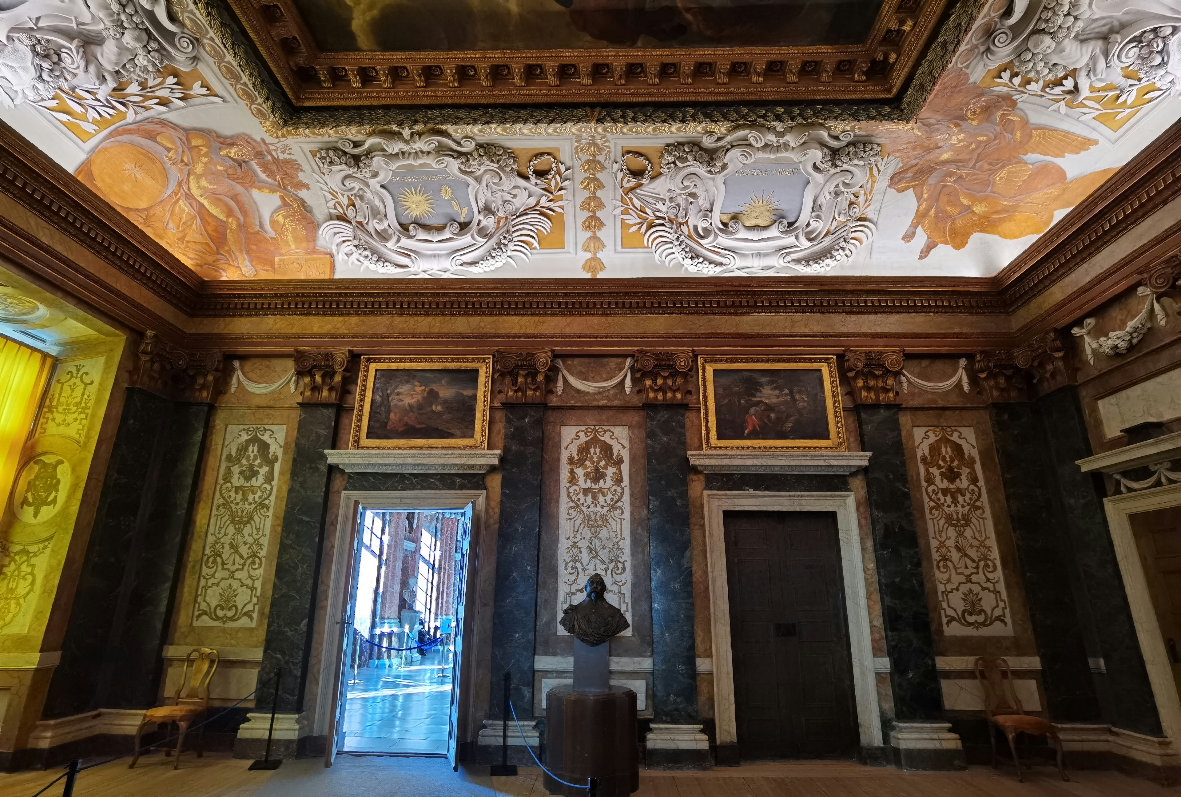 Interior of an ornate room featuring beautiful ceiling artwork and decorative walls