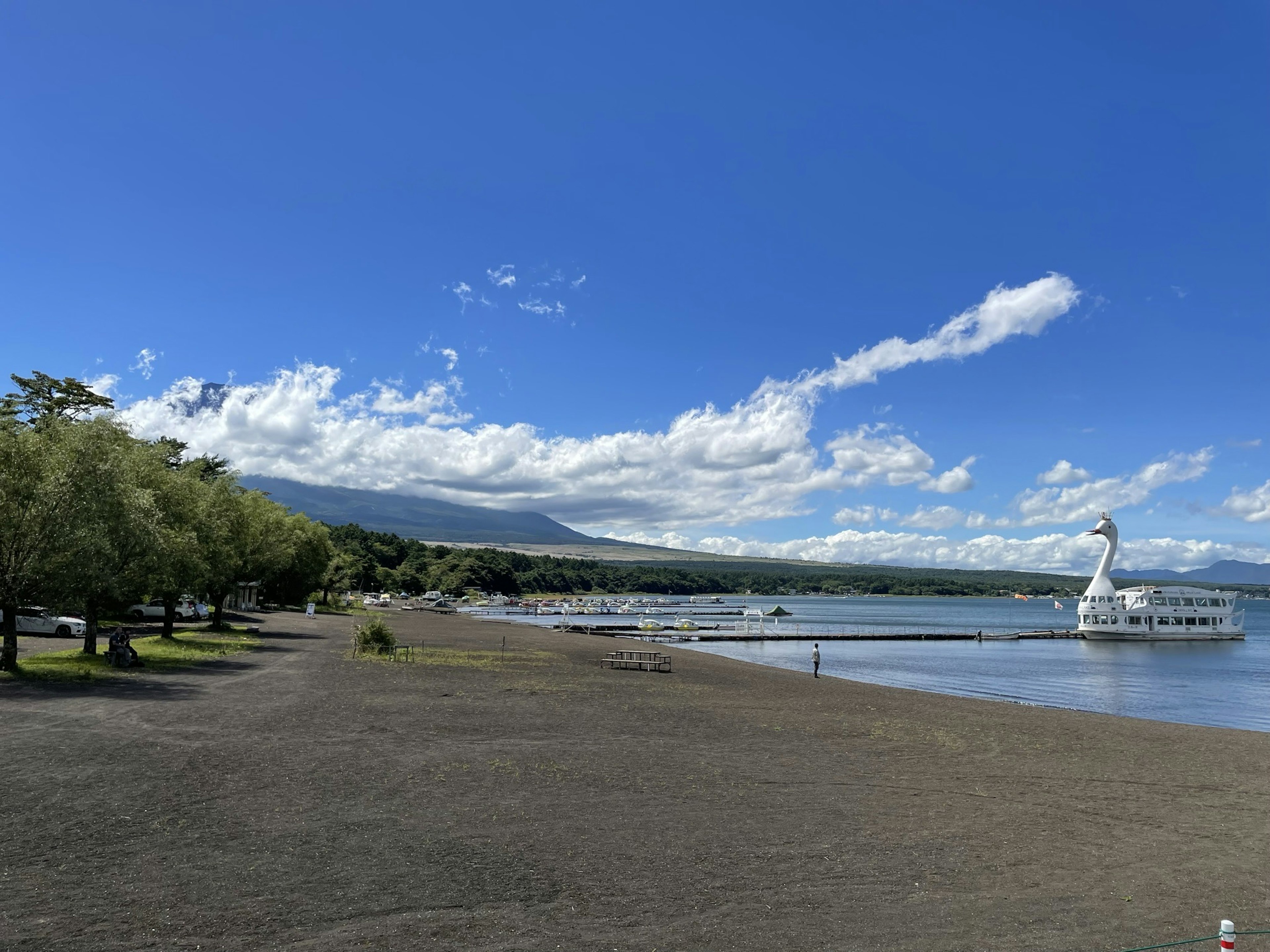 青空の下の砂浜とボートのある風景