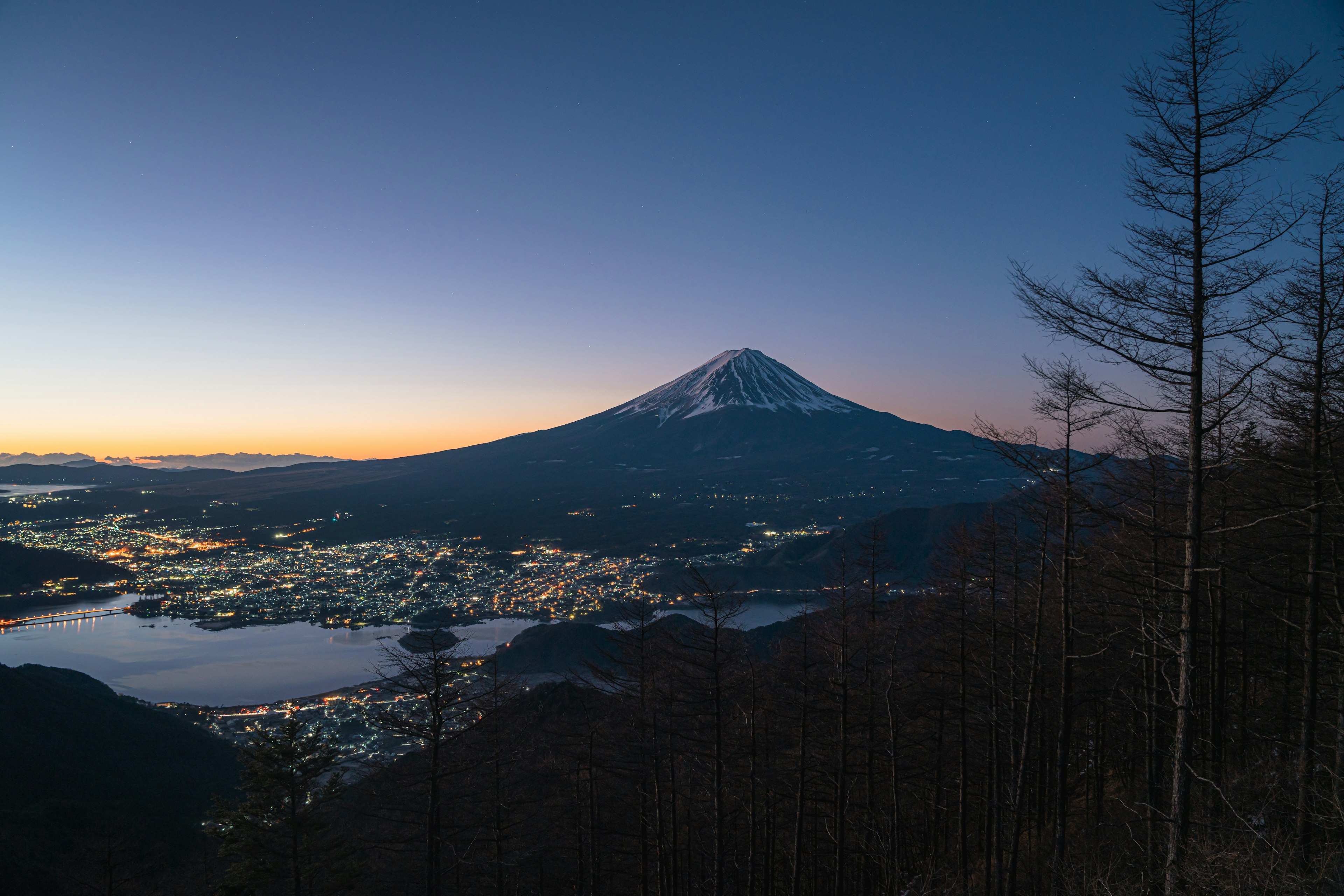 富士山壯麗的日落景觀，城市和湖泊的燈光