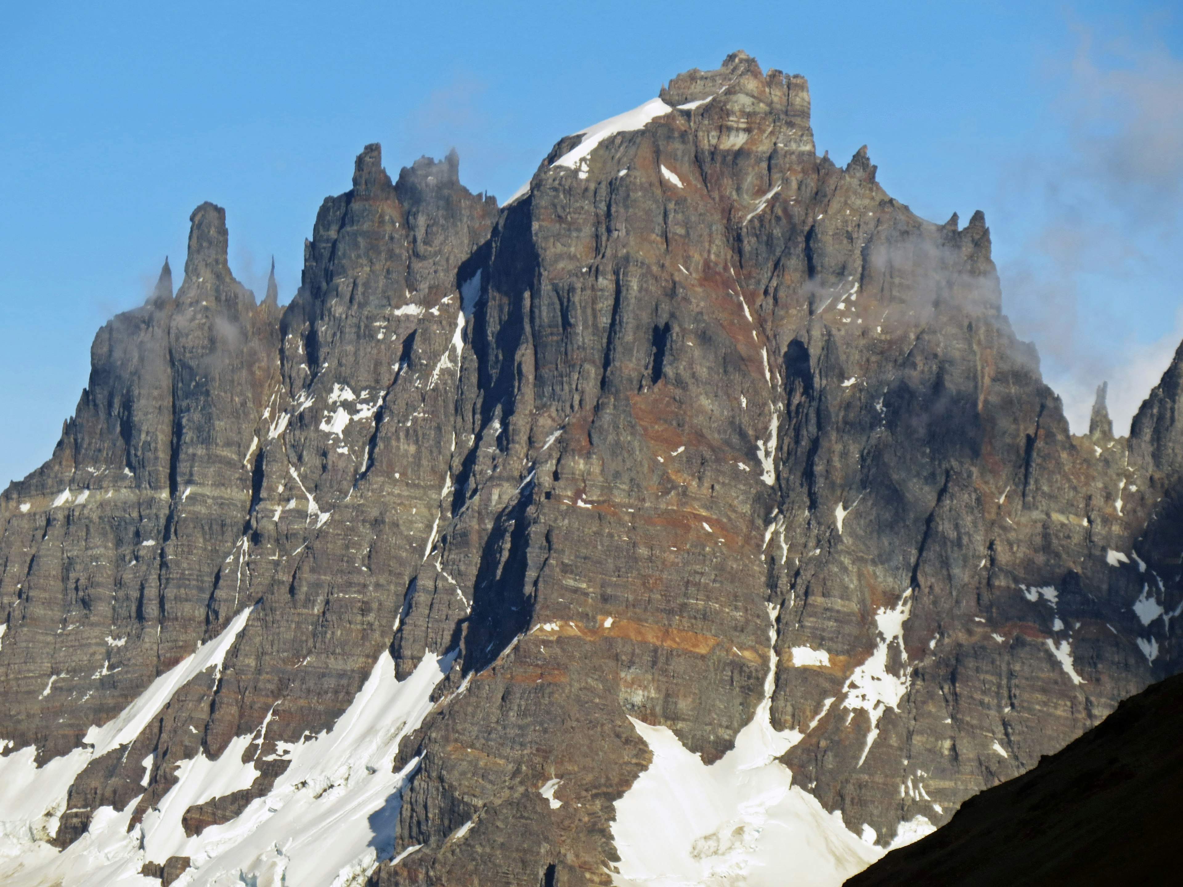 Picco di montagna maestoso con scogliere impervie e pendii coperti di neve