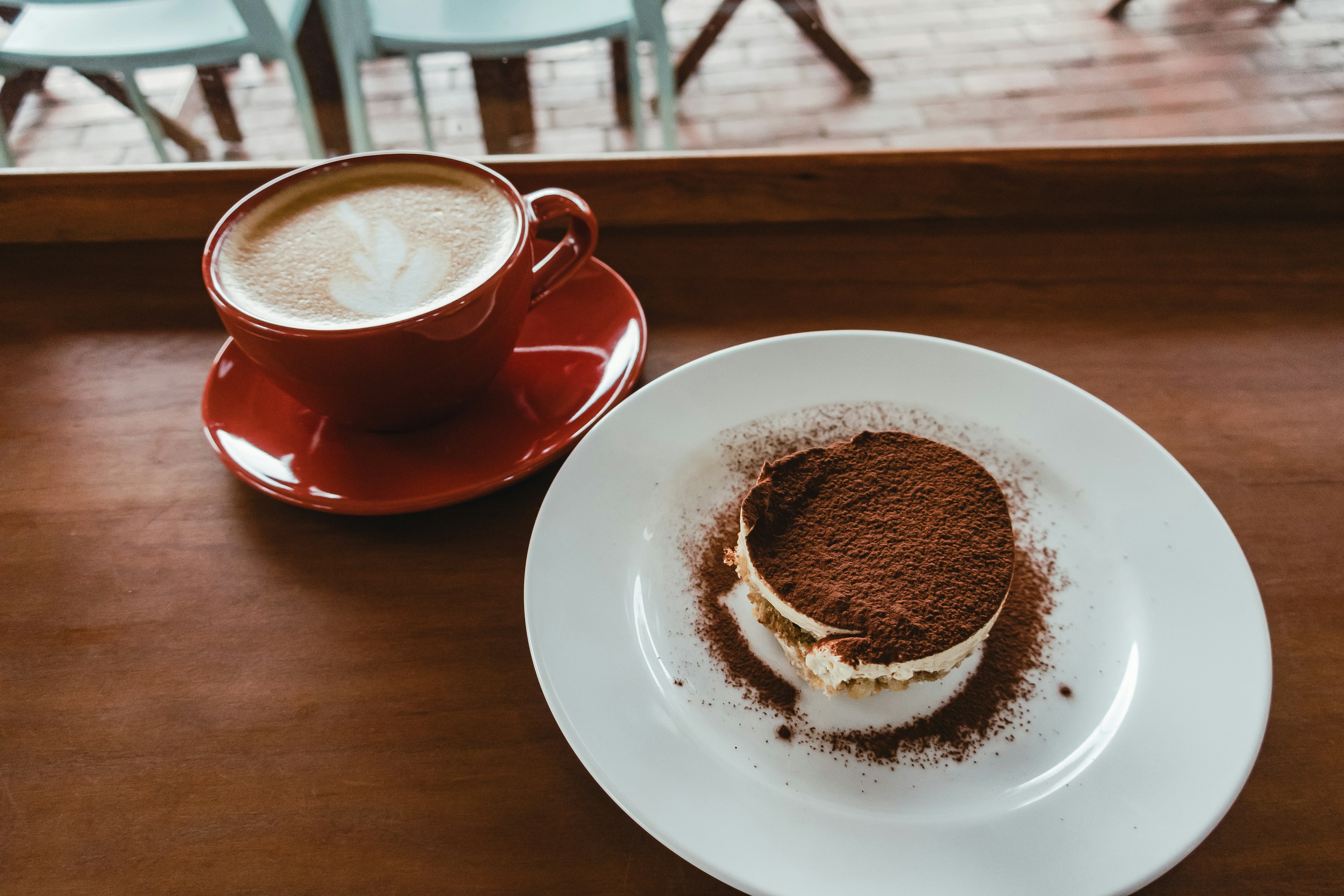 Gambar yang menampilkan kopi dan makanan penutup tiramisu yang disajikan dengan indah