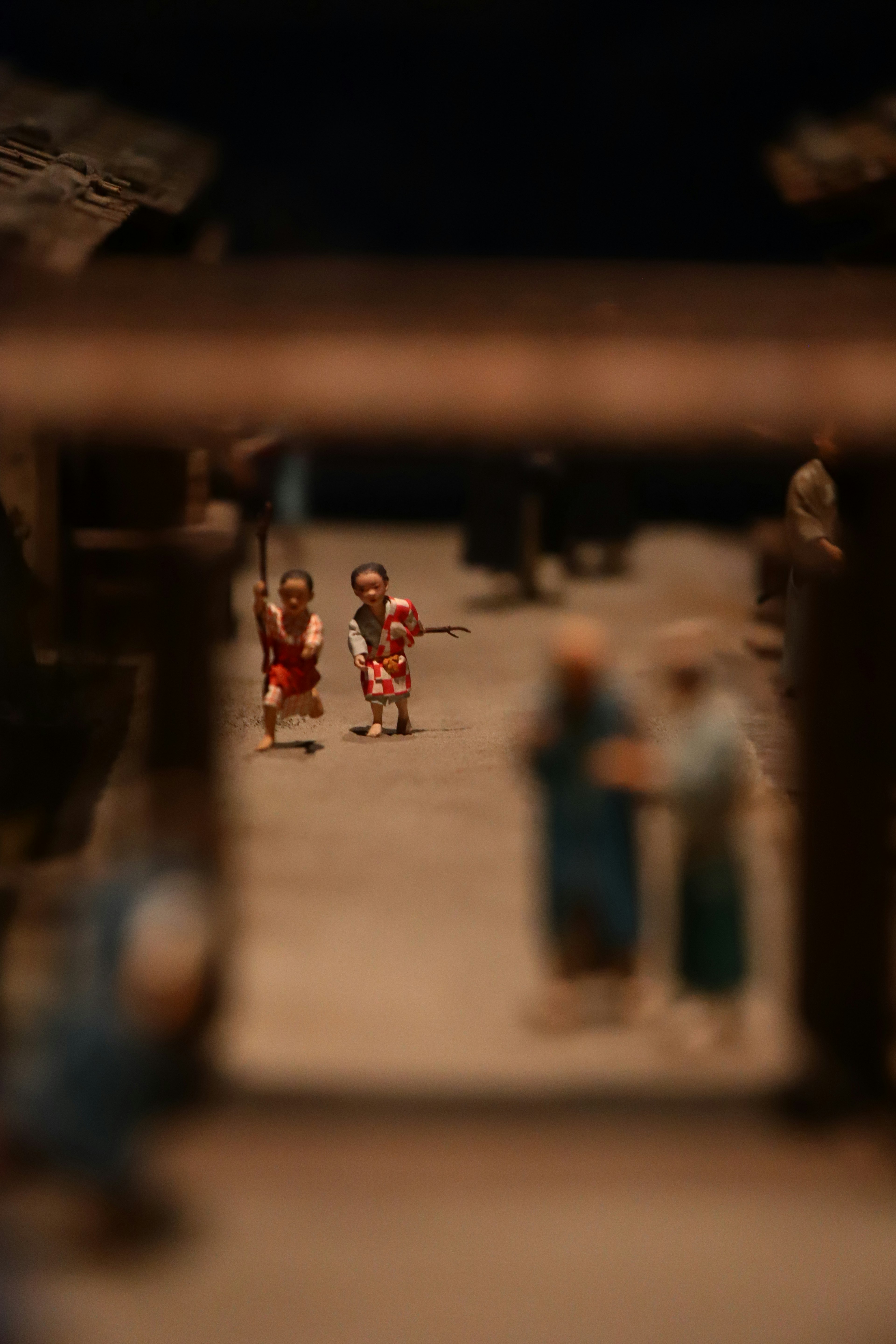 Blurry scene with two small figures smiling in the foreground