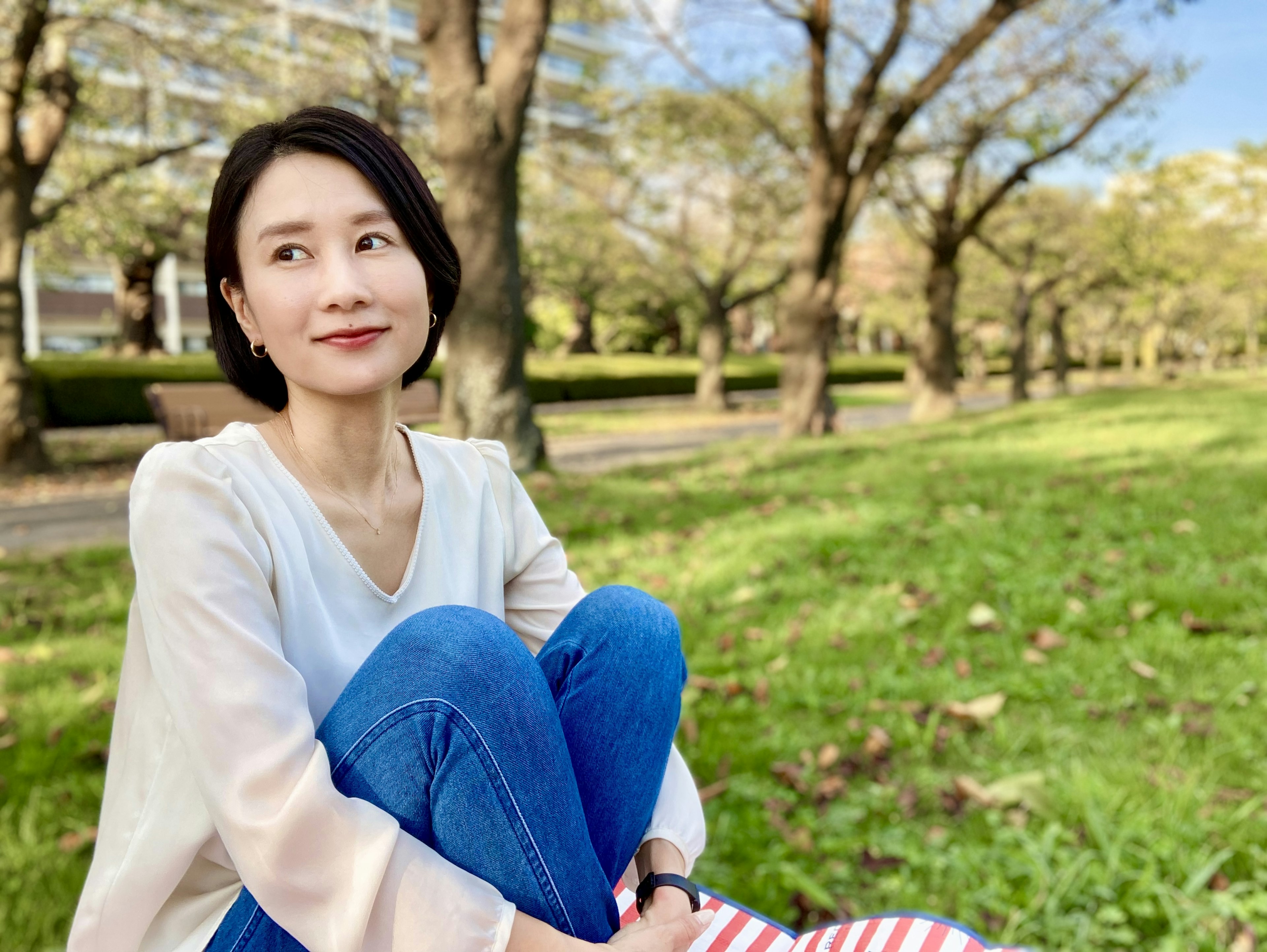 Retrato de una mujer relajándose en un parque rodeada de vegetación