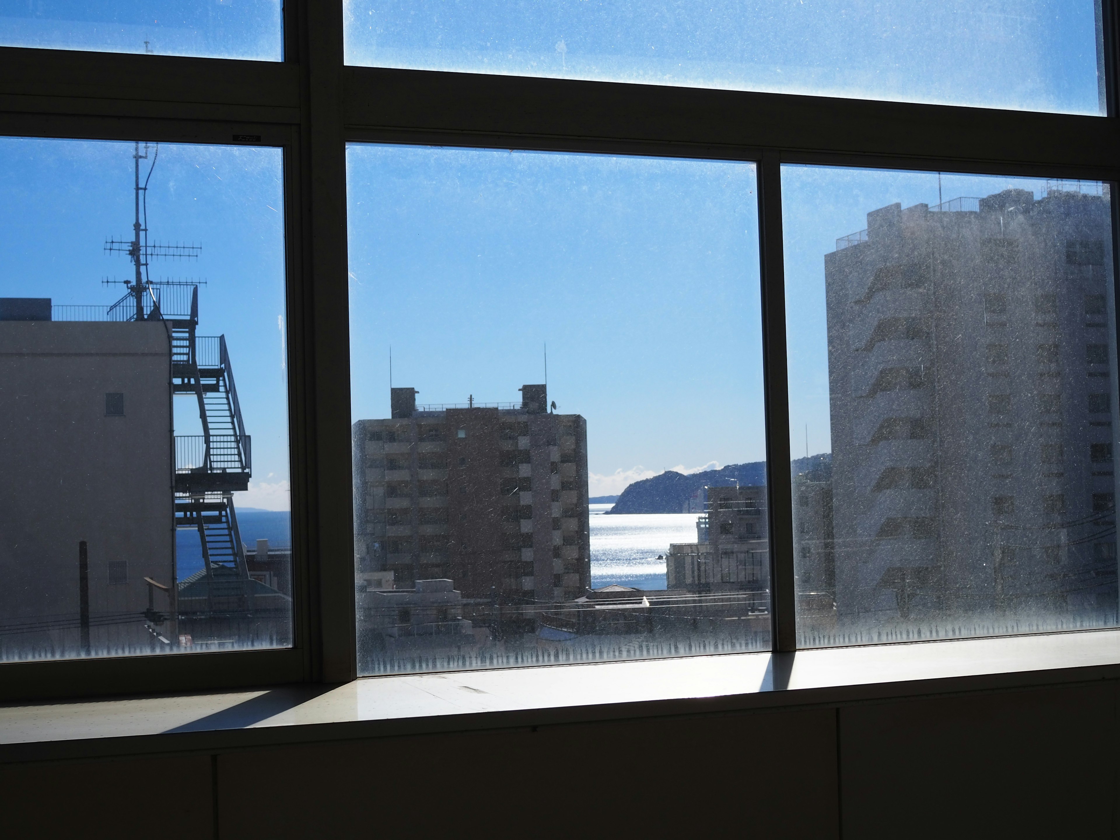 Vue de la mer et des bâtiments depuis une fenêtre