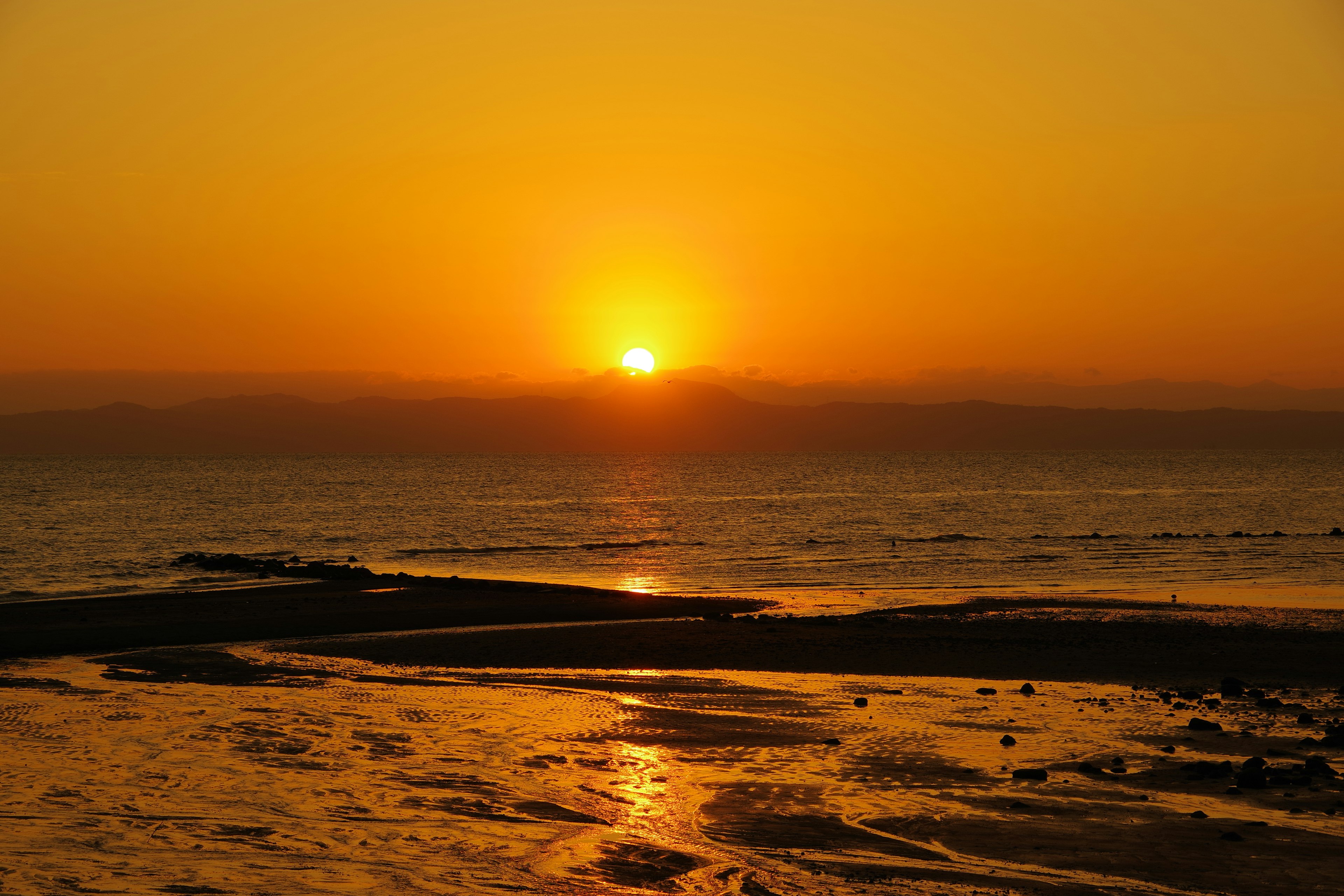 Beautiful landscape of sunset over the sea orange light reflecting on the water