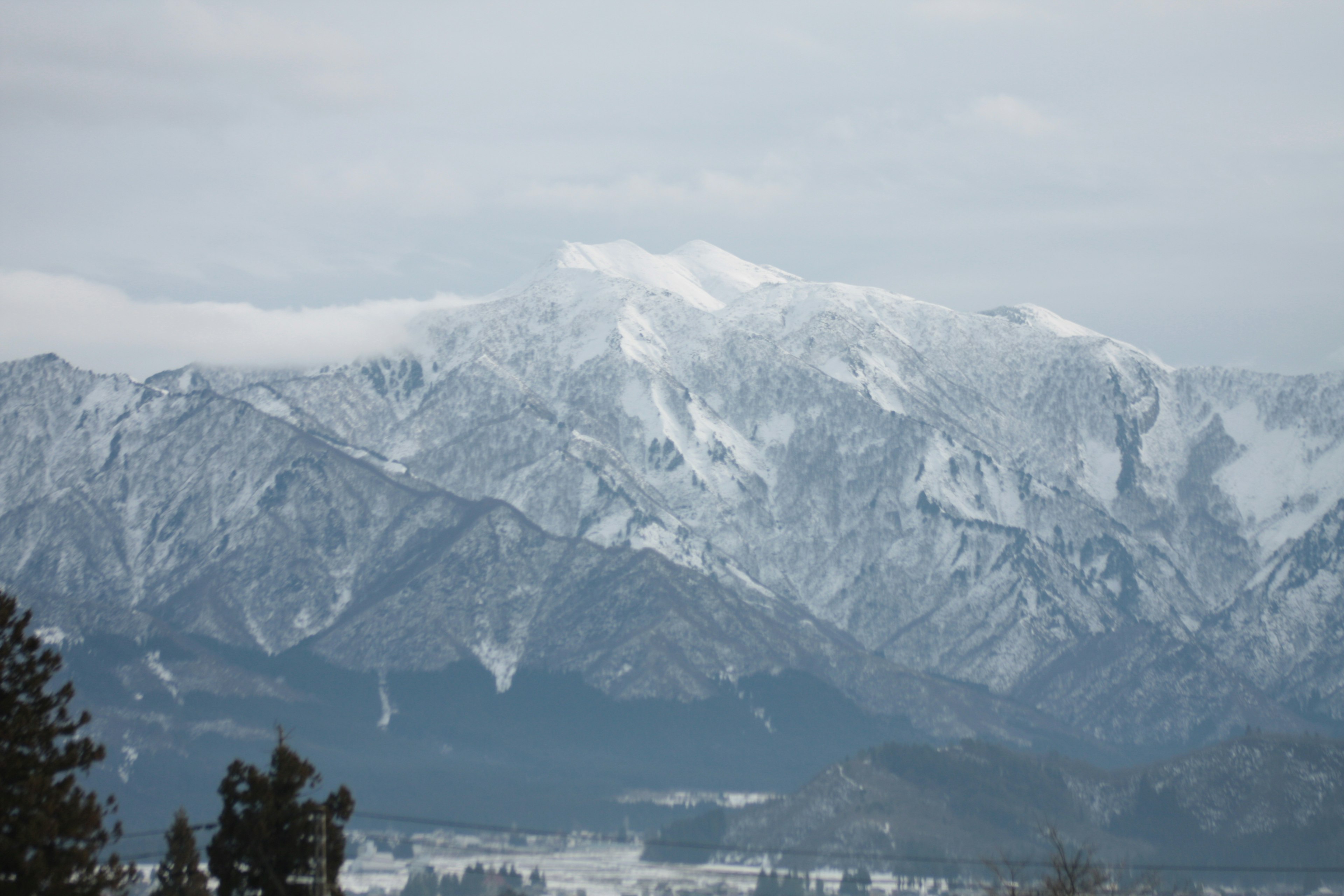 Snow-covered mountain range under a cloudy sky