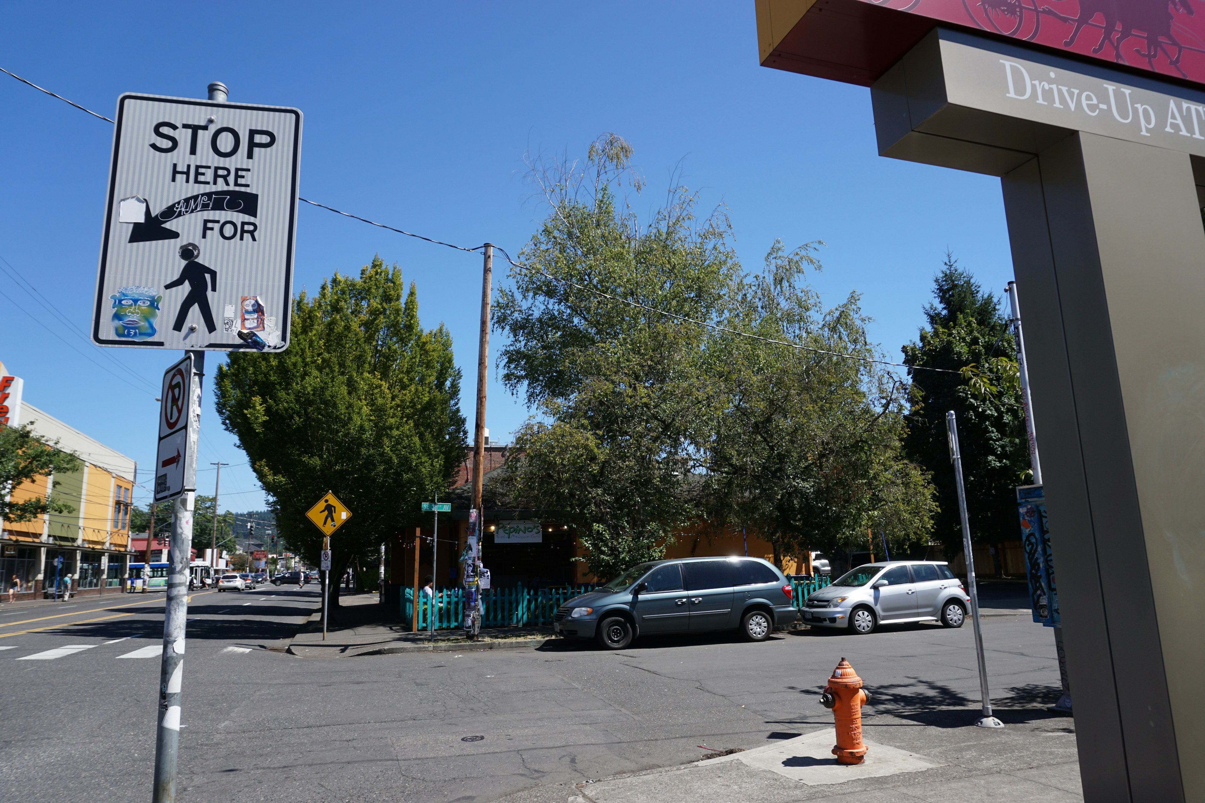 Vista de una esquina de calle con señal de alto y semáforo peatonal