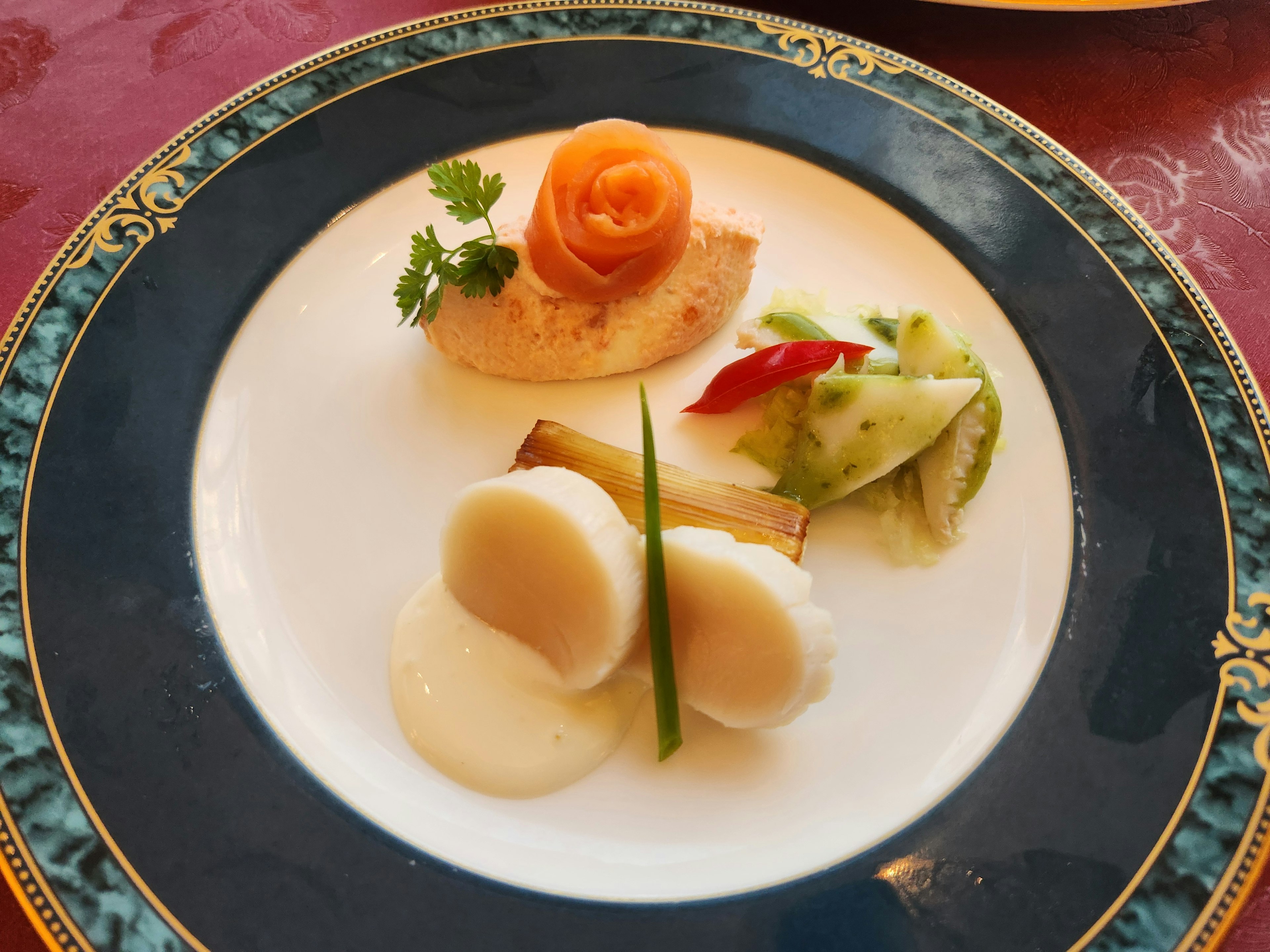 Elegant dish served on a decorative plate featuring salmon rose and creamy seafood