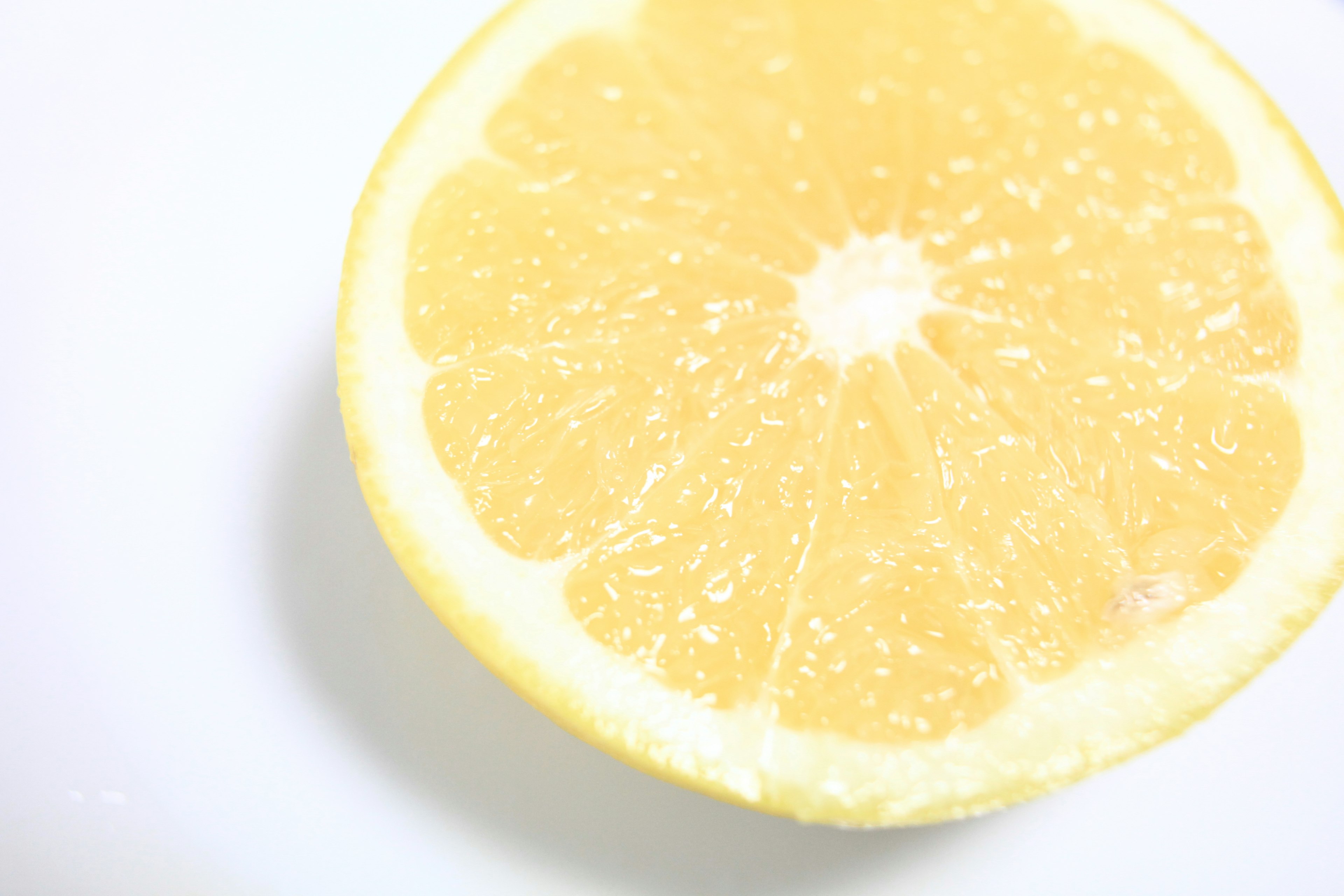 A yellow lemon cut in half on a white plate