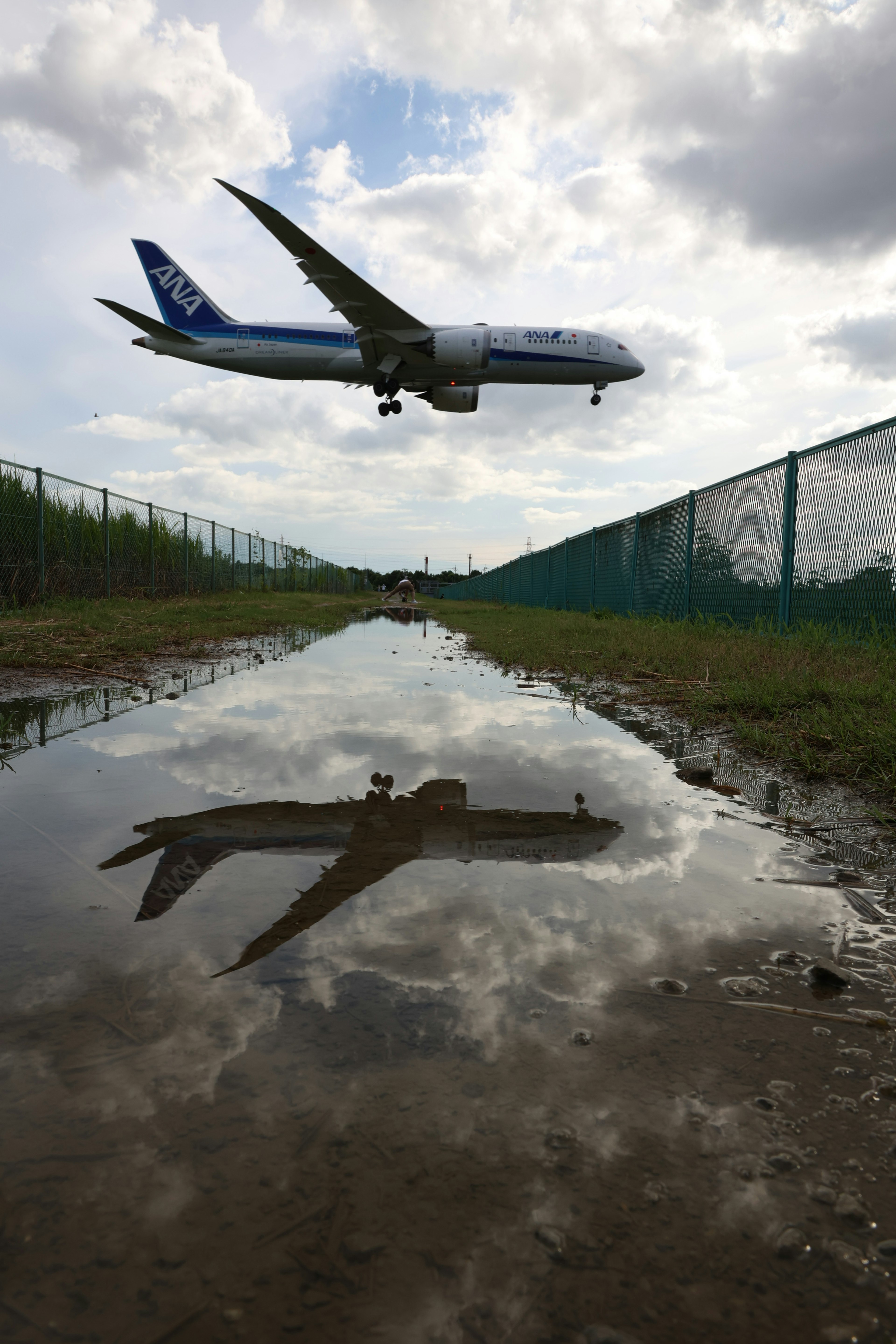 Avion volant bas au-dessus d'une flaque reflétant son image