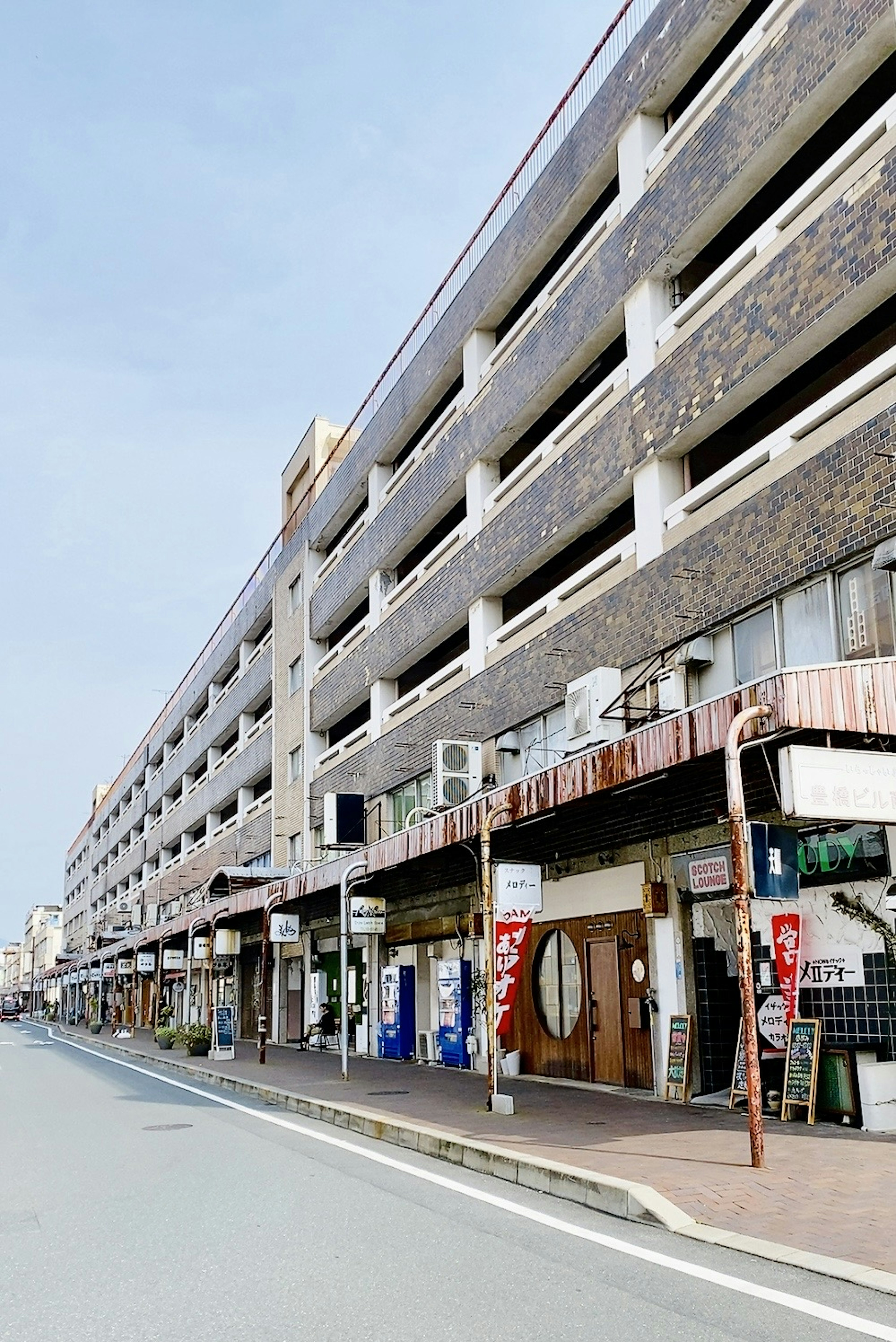 Facciata di un vecchio edificio commerciale lungo una strada tranquilla