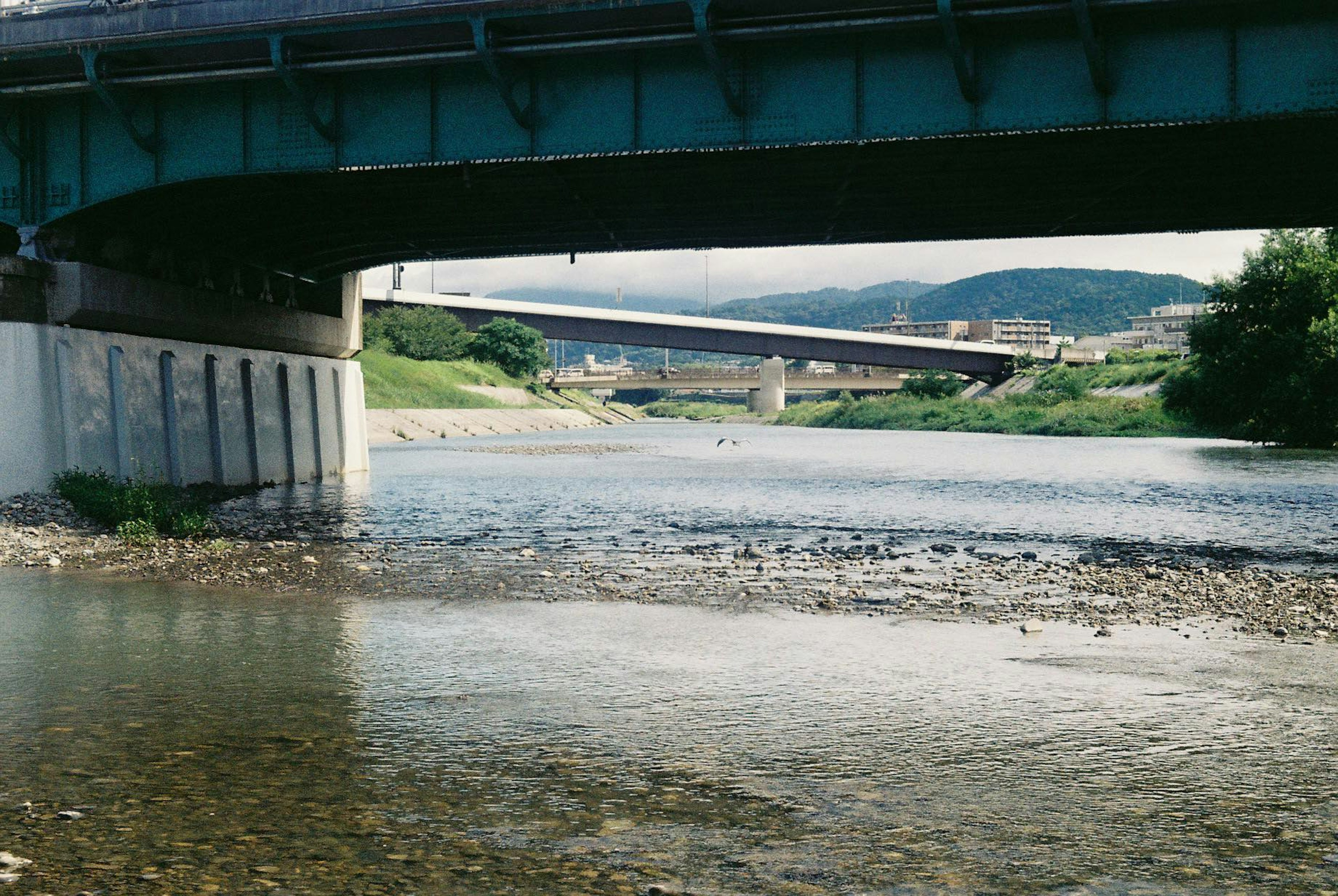 Vista di un ponte blu sopra un fiume con un altro ponte in lontananza