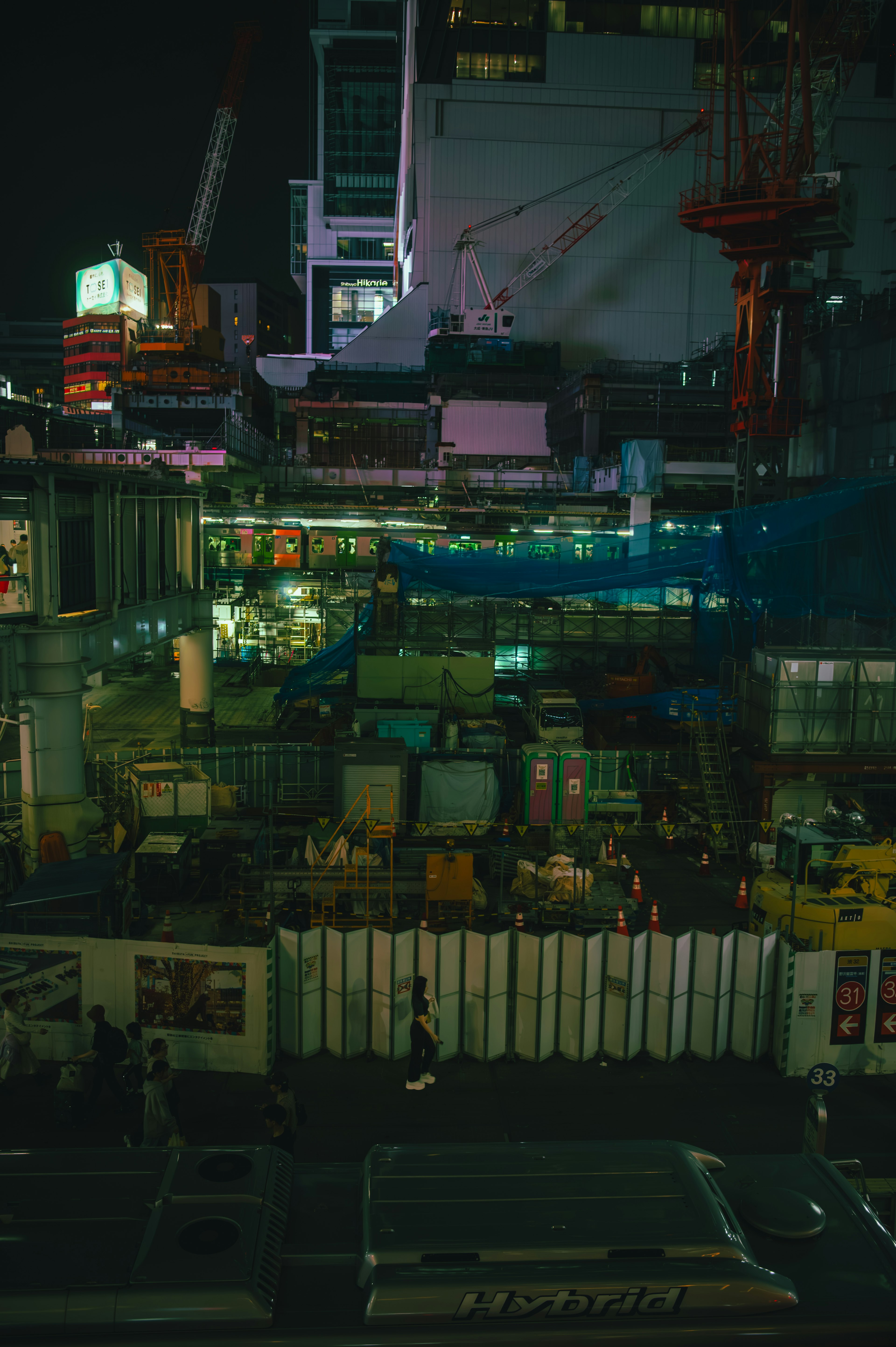 Brightly lit construction site at night with complex structures