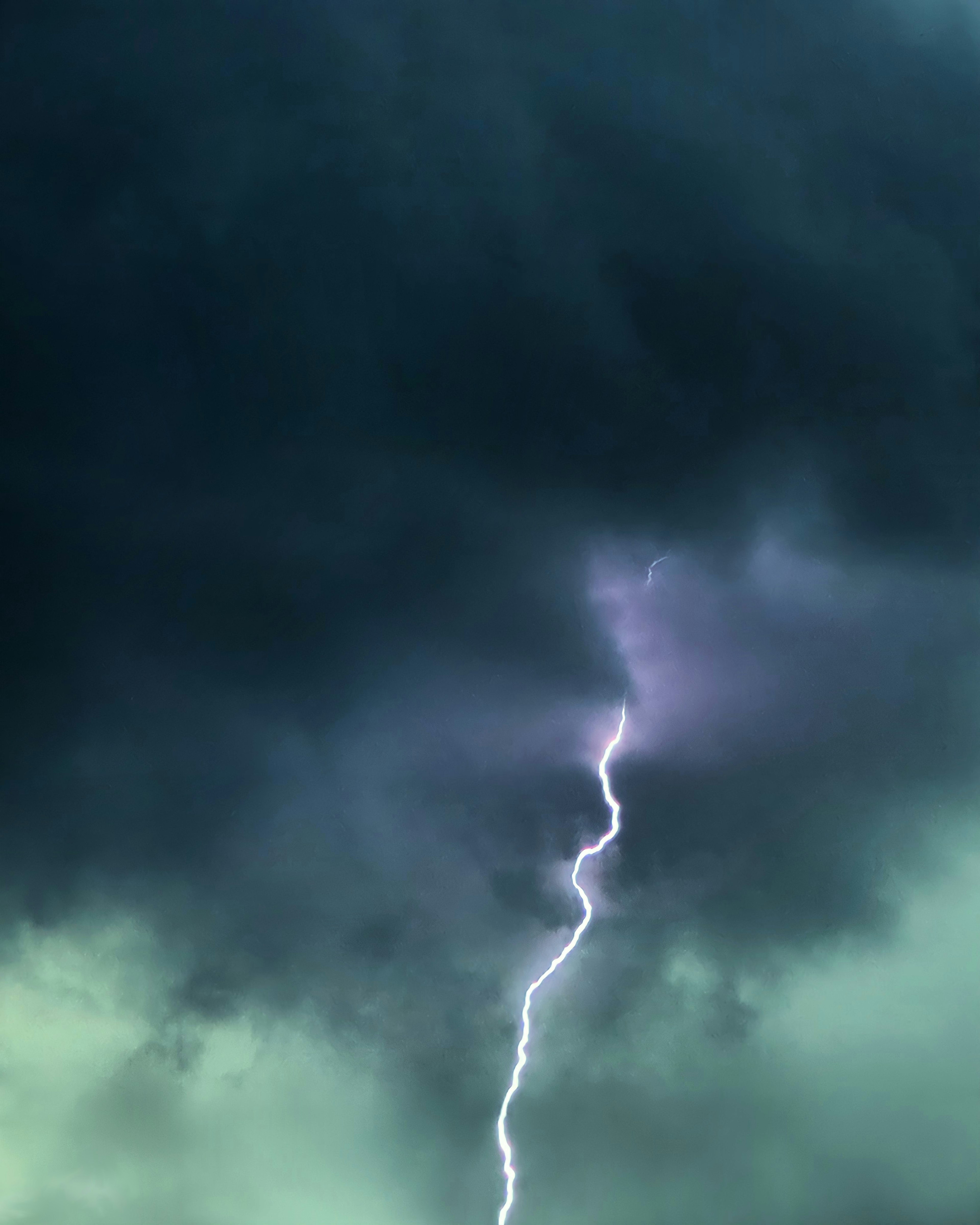 Lightning striking through dark clouds