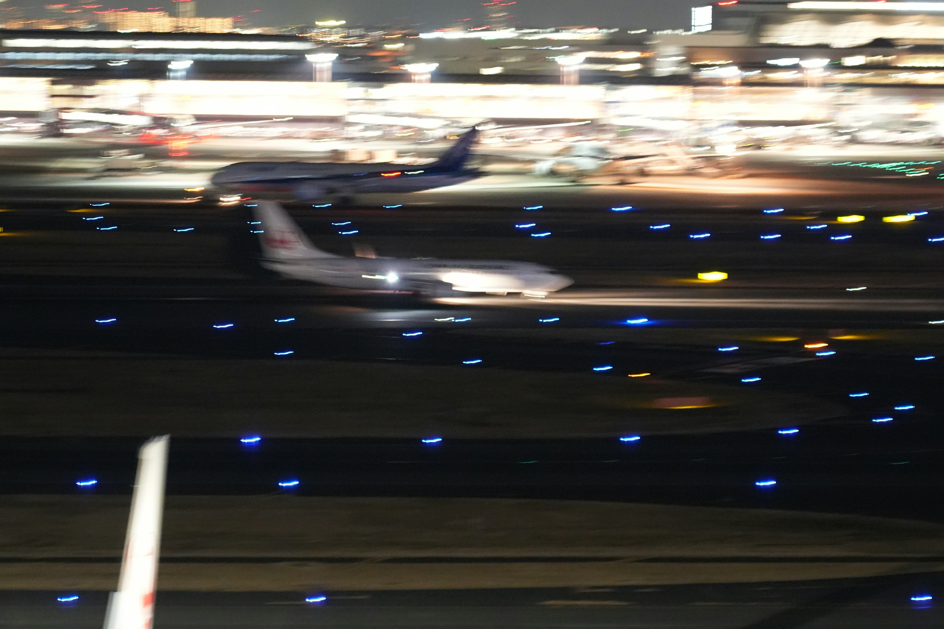 夜間滑行的飛機和照亮的跑道燈