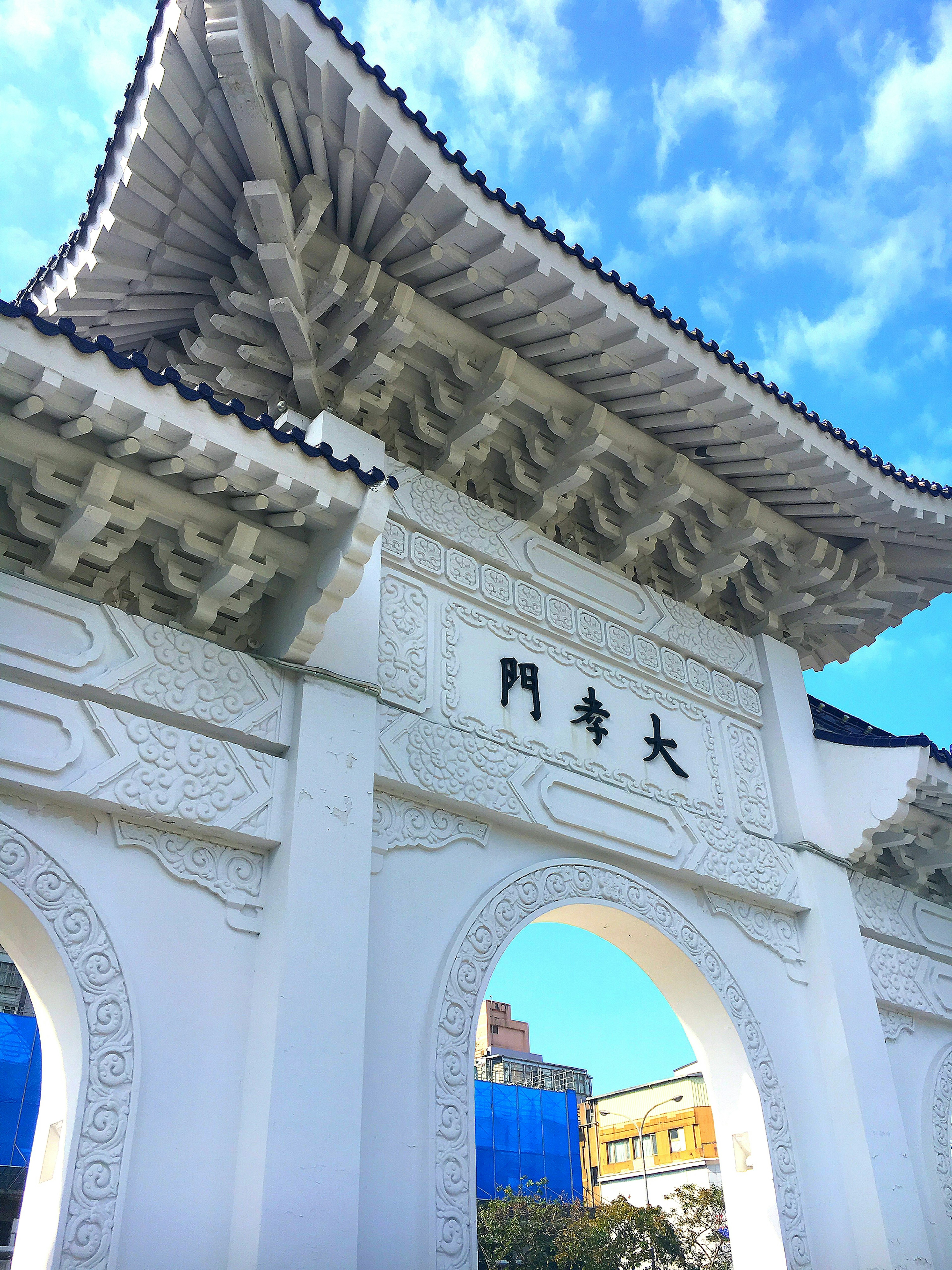 Arco blanco tradicional con detalles intrincados contra un cielo azul