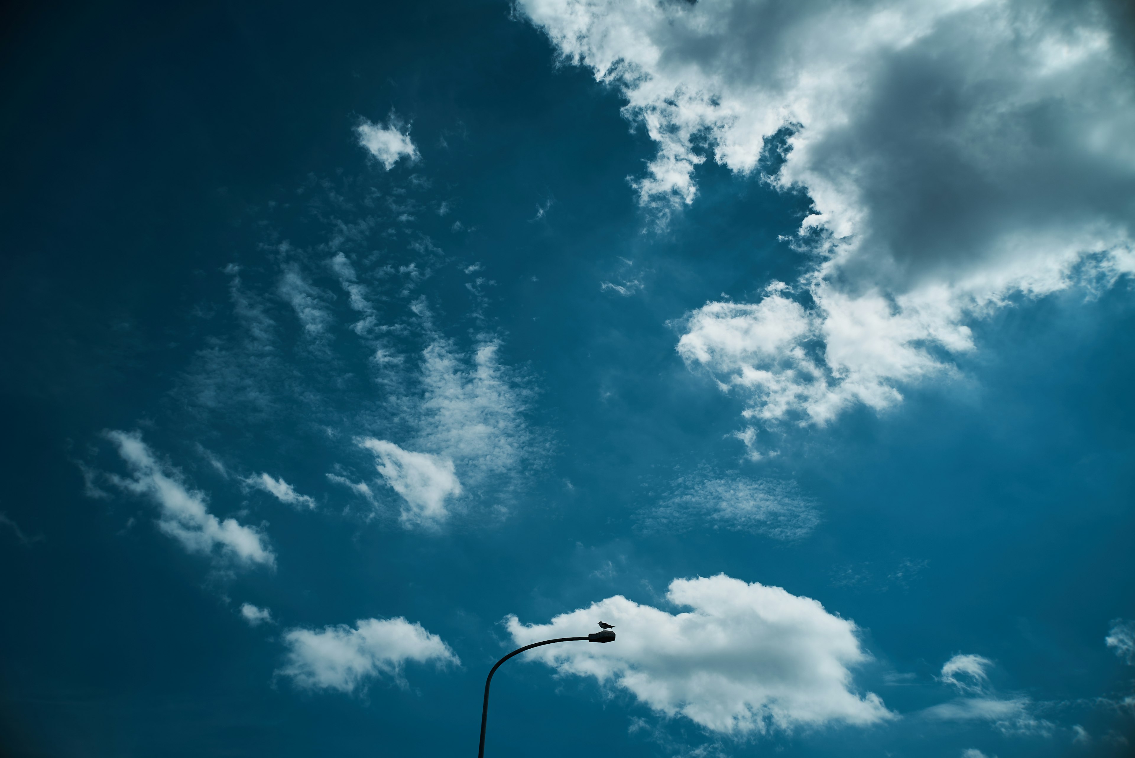 Cielo azul con nubes blancas y una farola