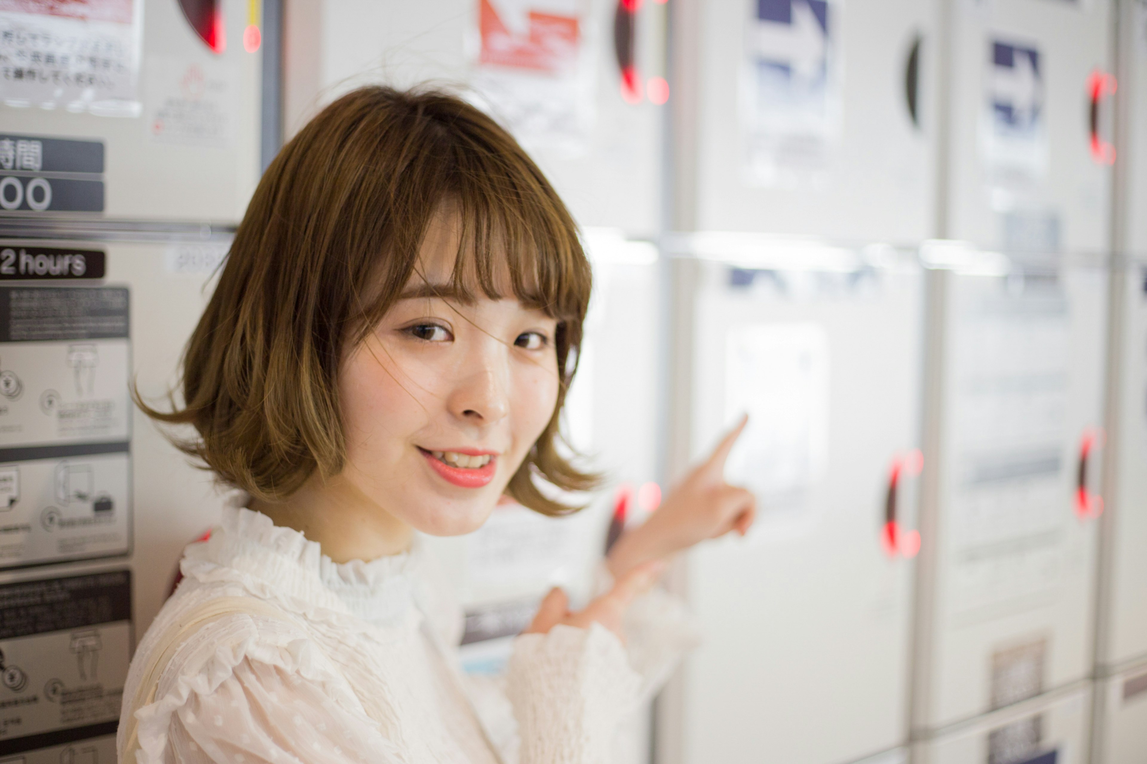 A woman smiling and pointing at a menu in front of a restaurant