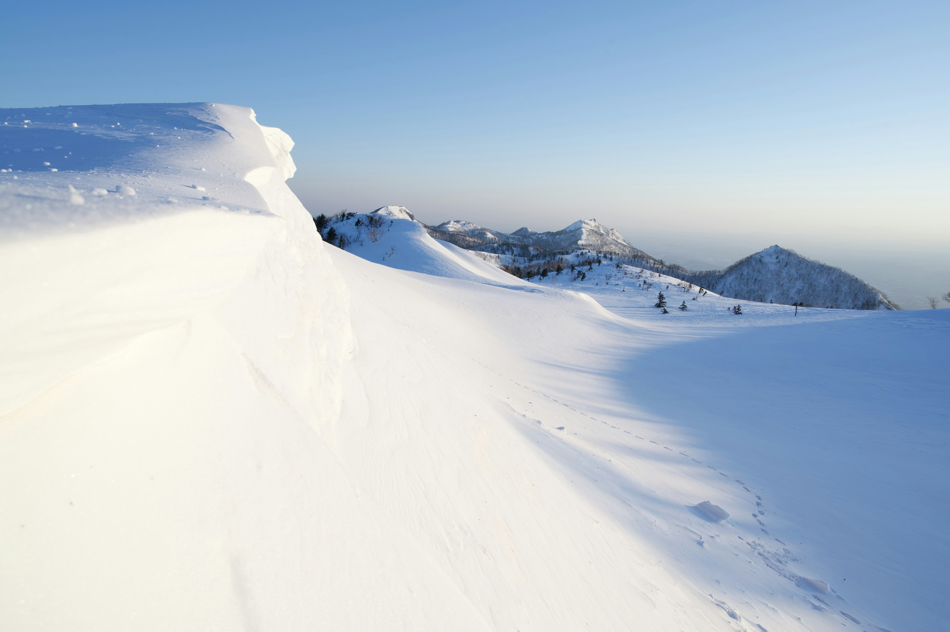 Paesaggio montano coperto di neve con cielo blu chiaro