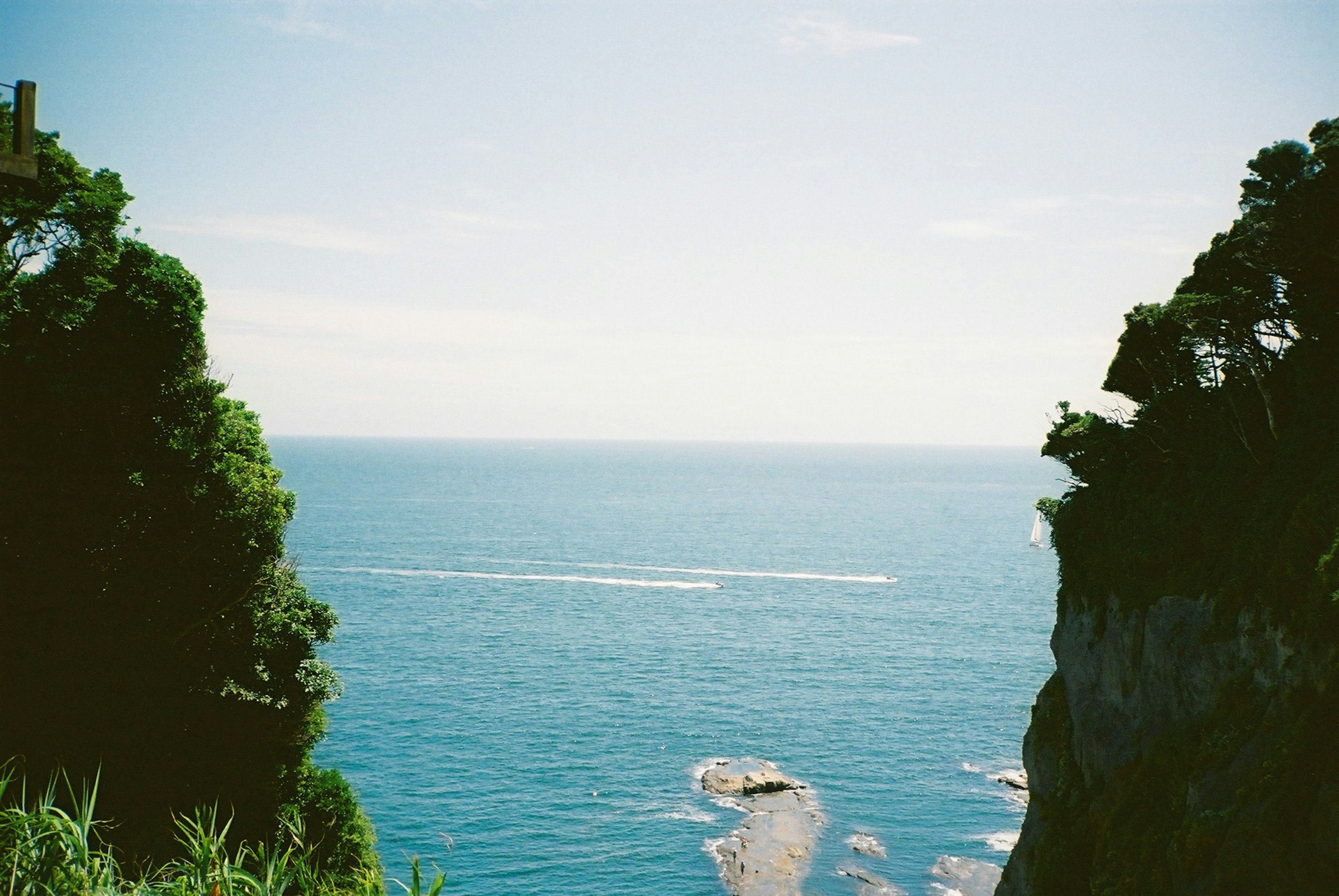 View between cliffs showcasing blue ocean and sky