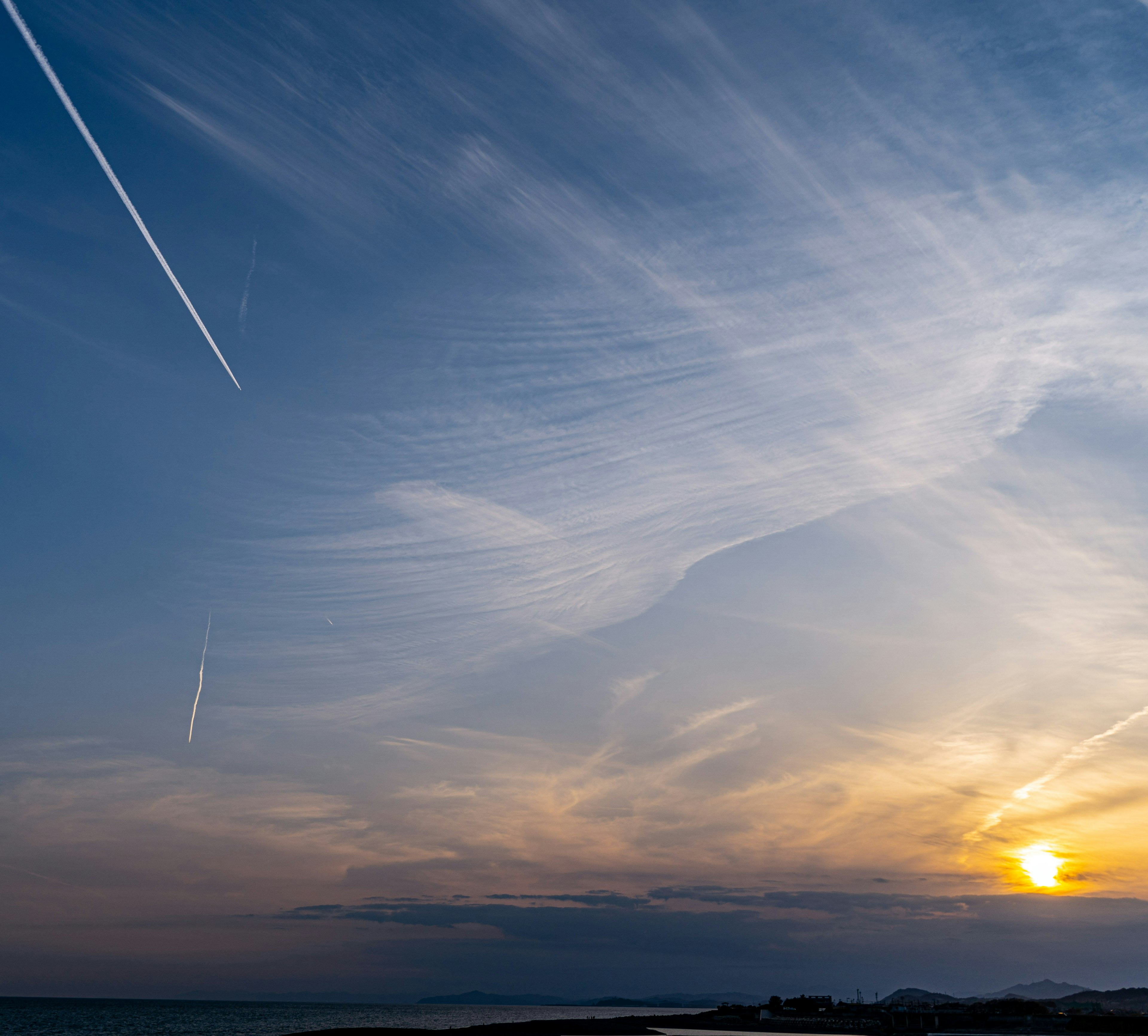 夕日と飛行機雲のある美しい空の風景