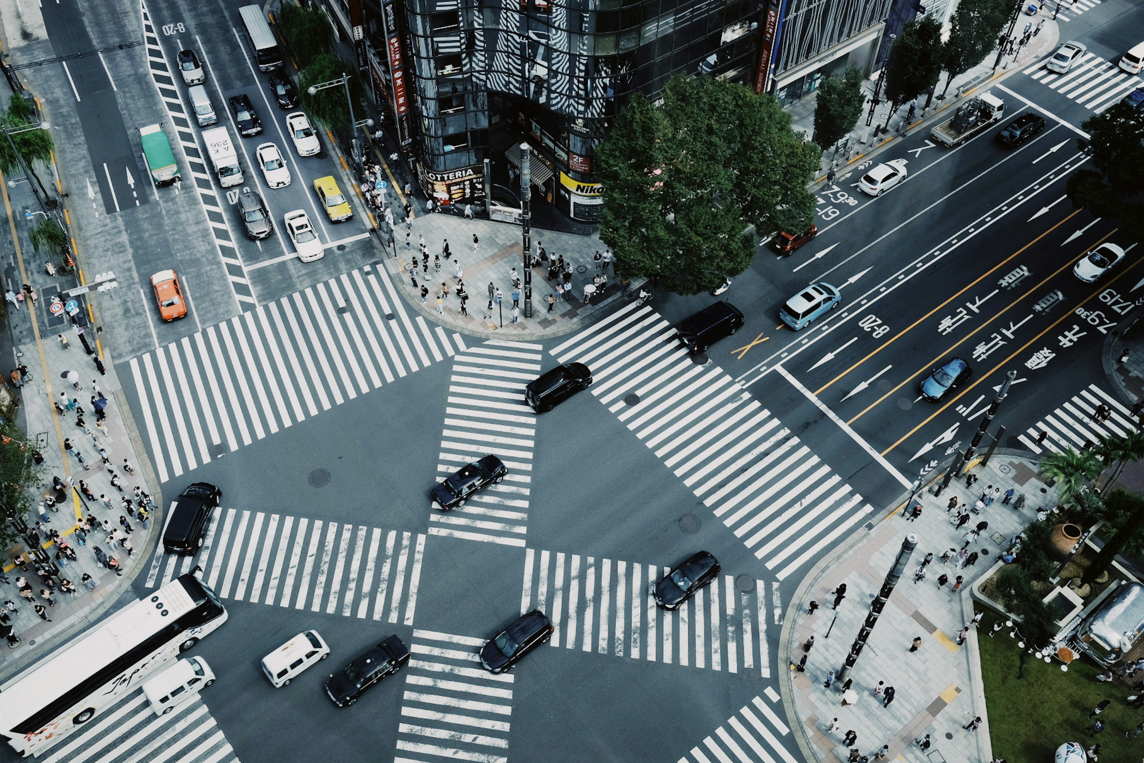 Aerial view of a busy intersection with pedestrians and vehicles