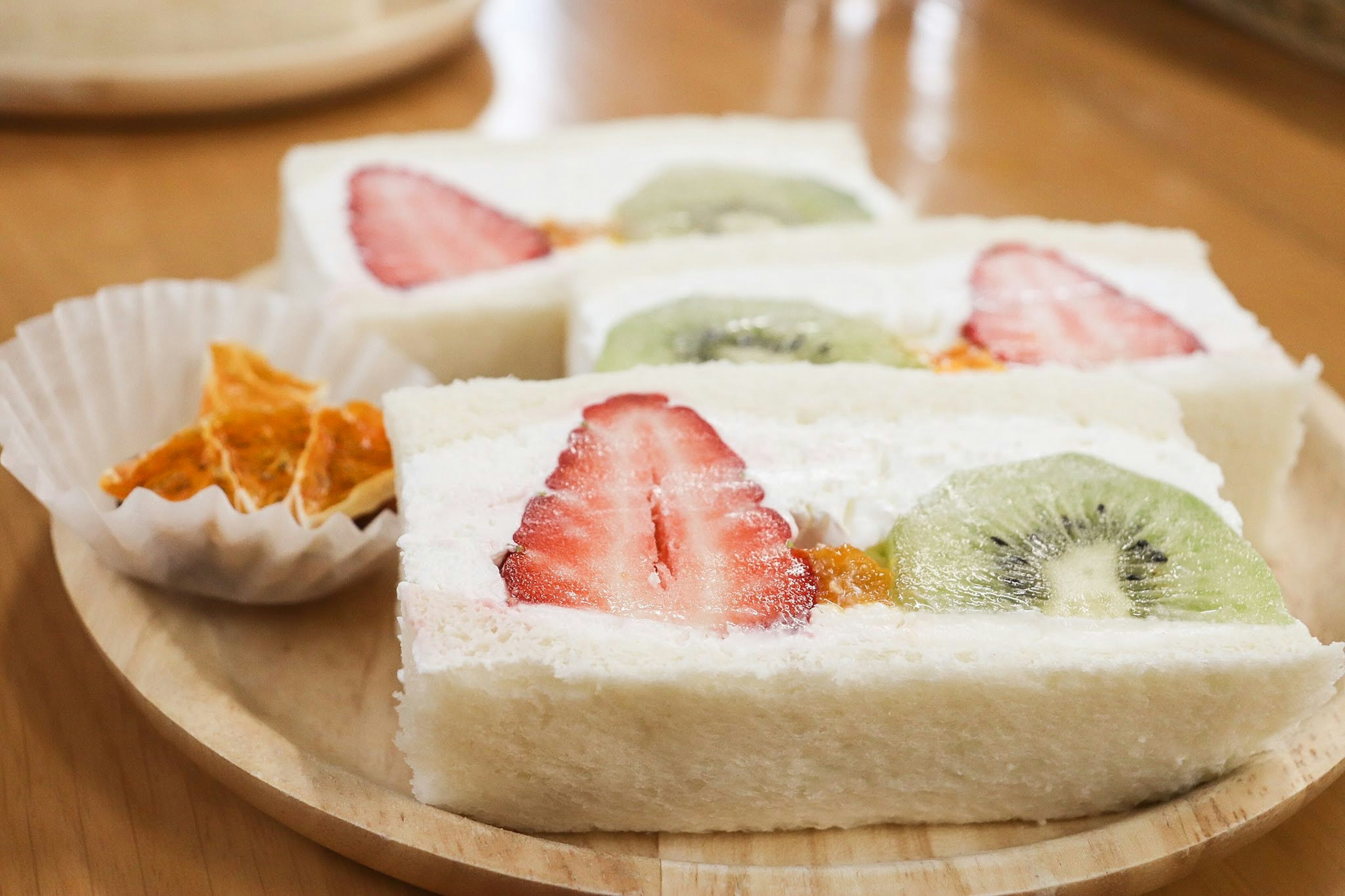 Sandwiches de fruits présentés sur une assiette en bois