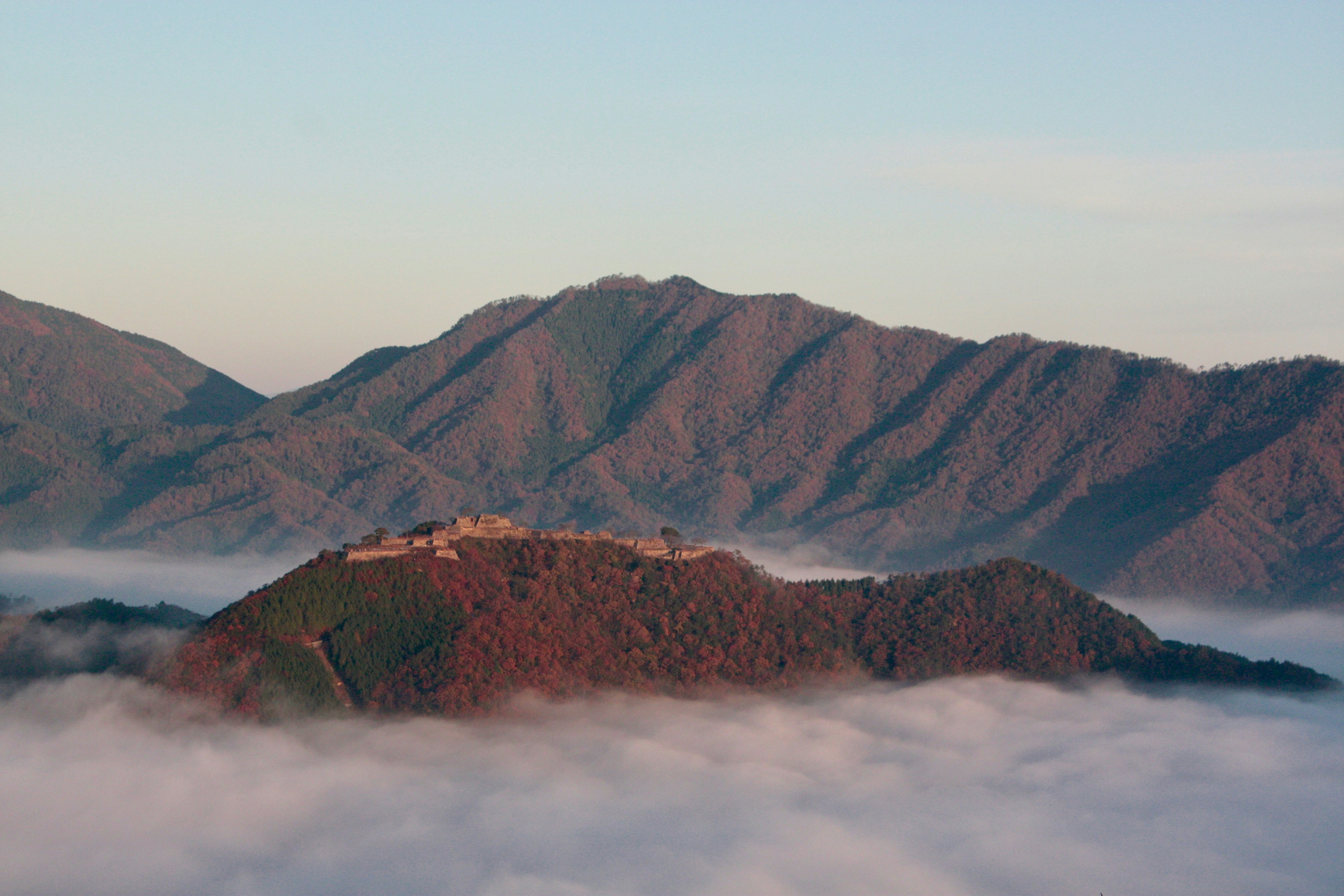 Paysage montagneux avec des ruines anciennes surplombant la brume