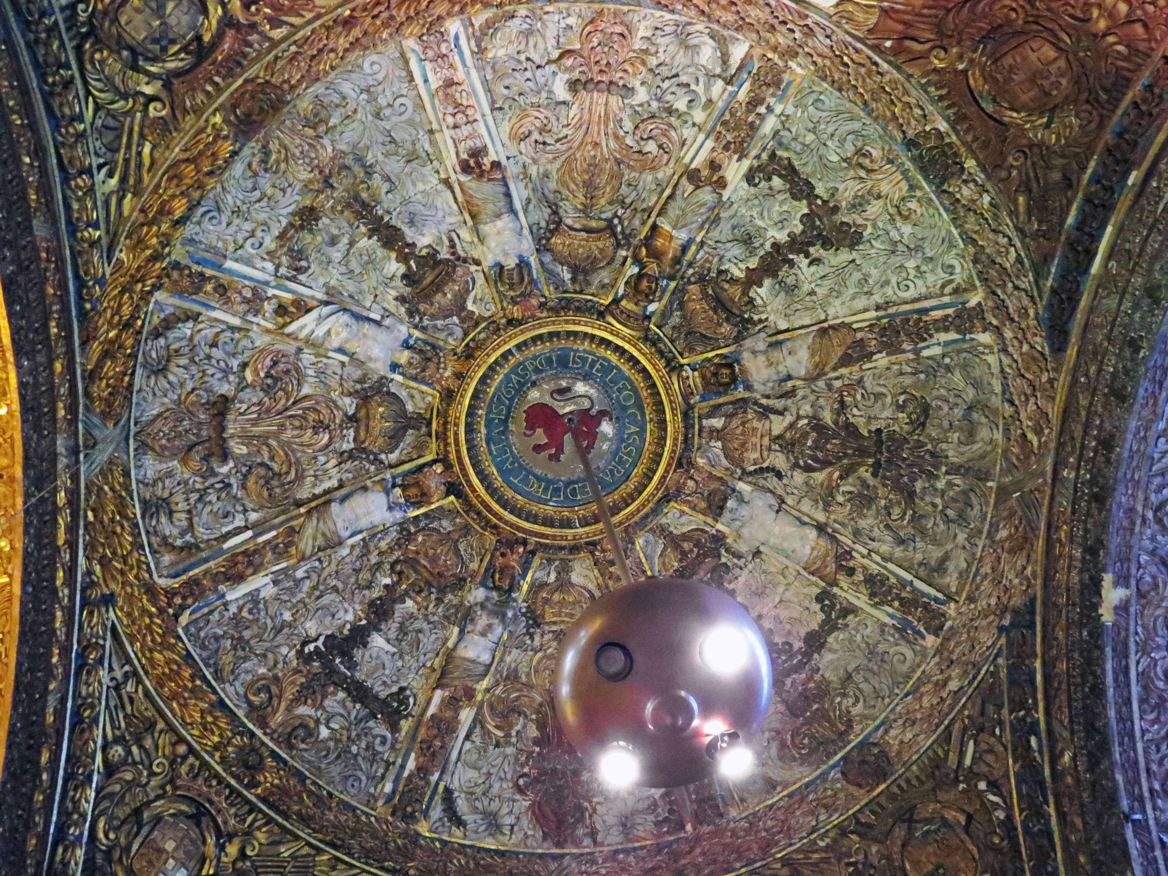 Historic building with ornate ceiling decoration and central painting