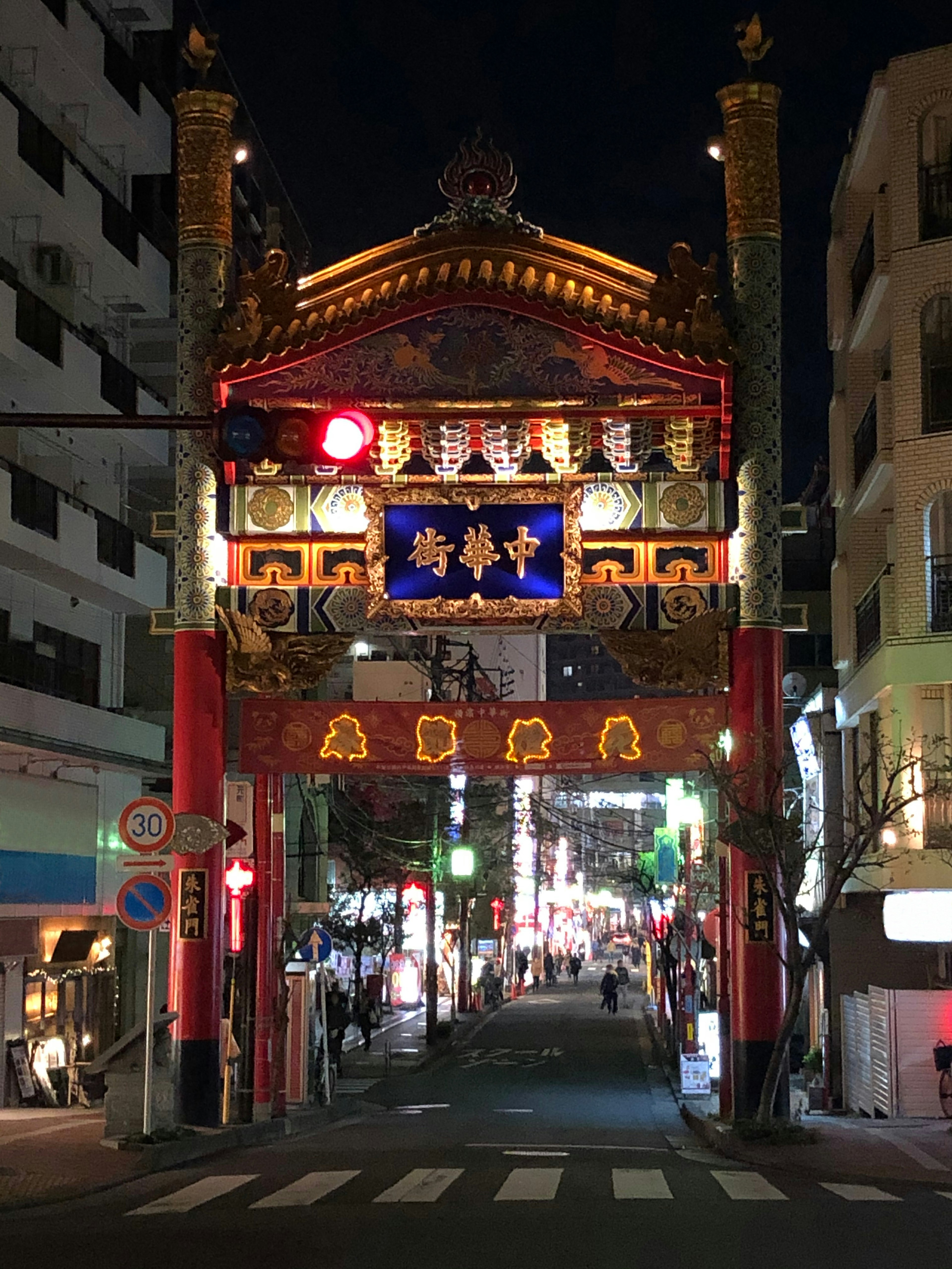 Torbogen von Chinatown bei Nacht mit rotem Ampellicht