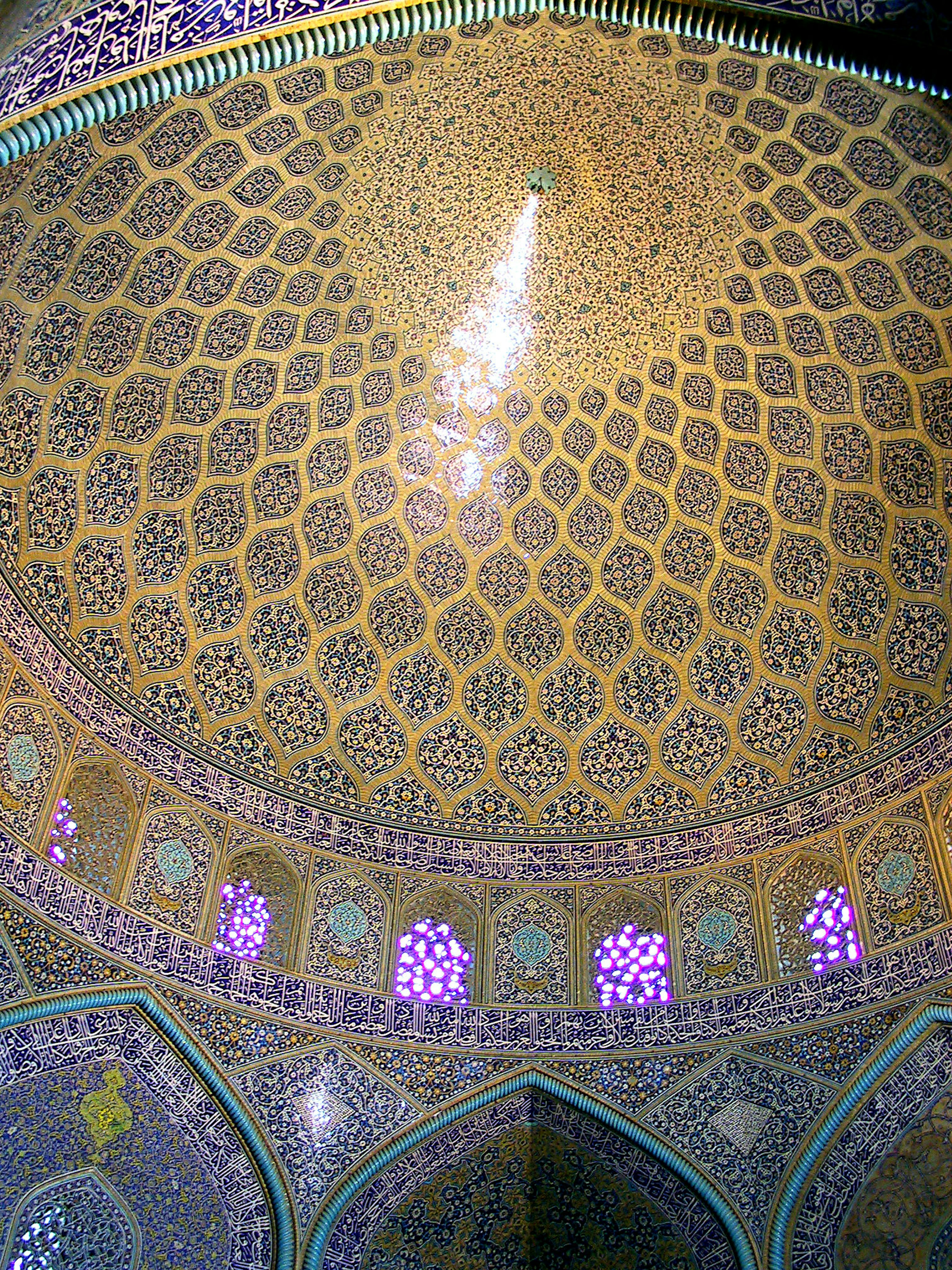 Interior de un edificio con una hermosa cúpula de mosaico y ventanas coloridas