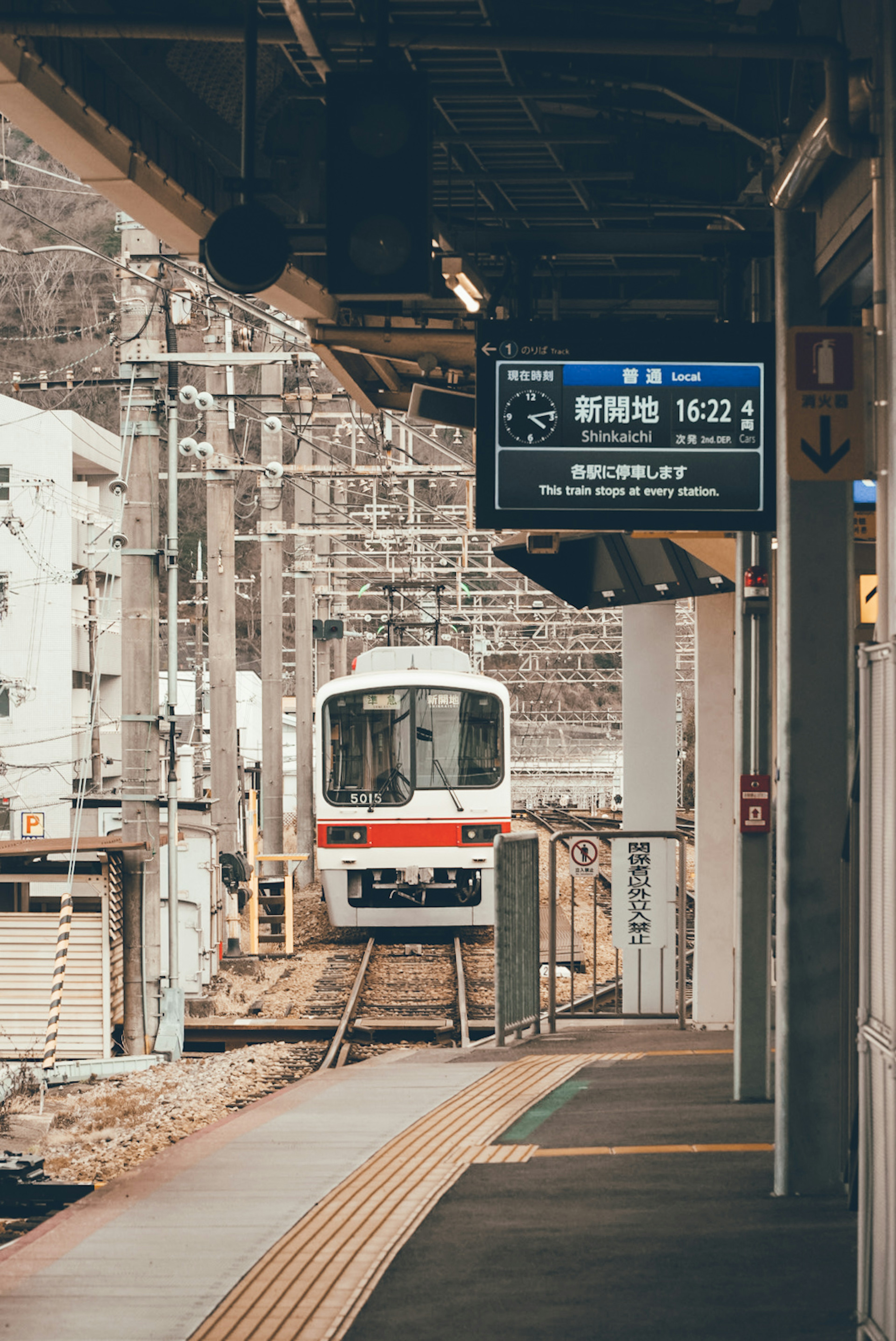 Scene of a train approaching a station with a display board