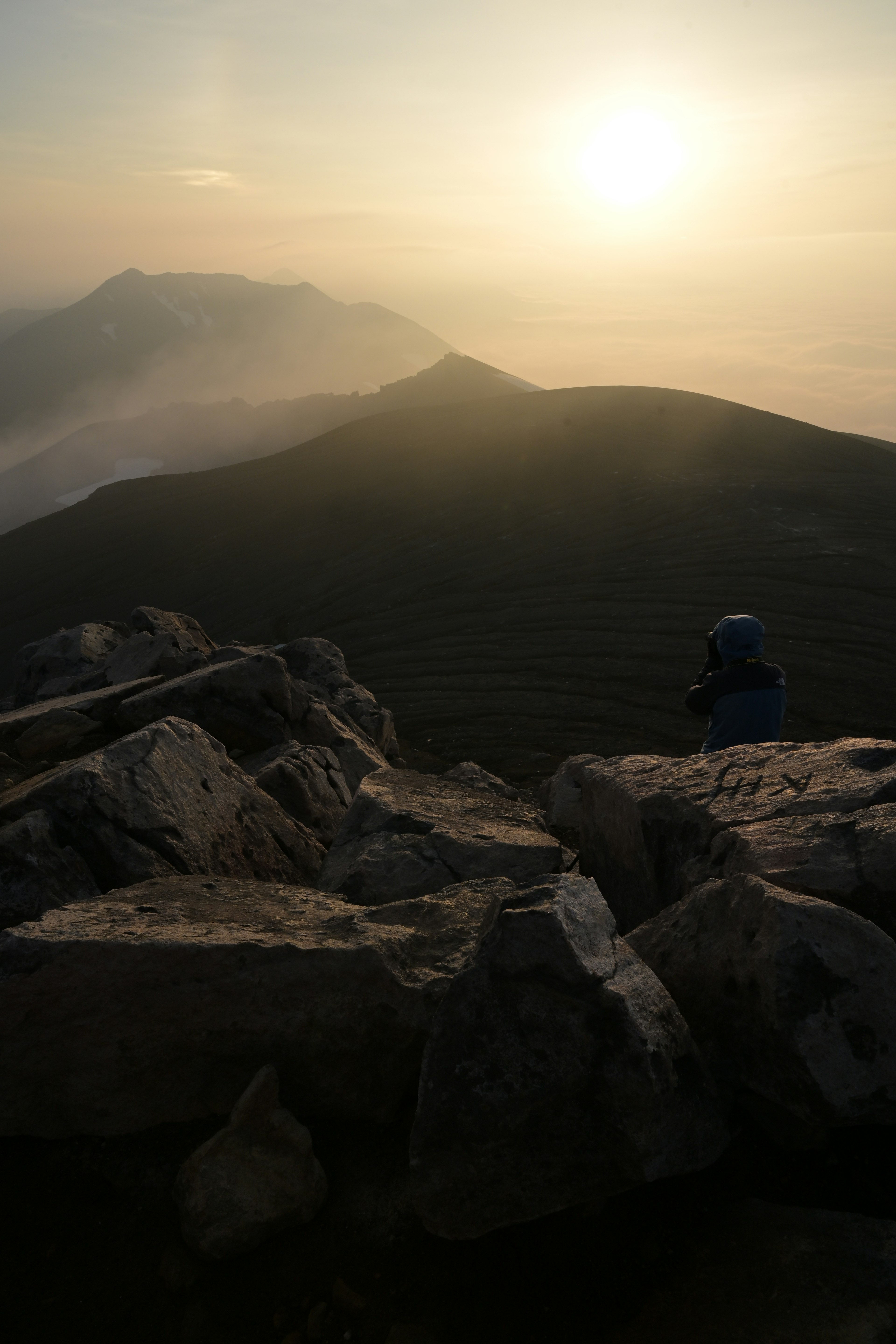 Stupenda vista dell'alba da una cima montuosa con un primo piano roccioso