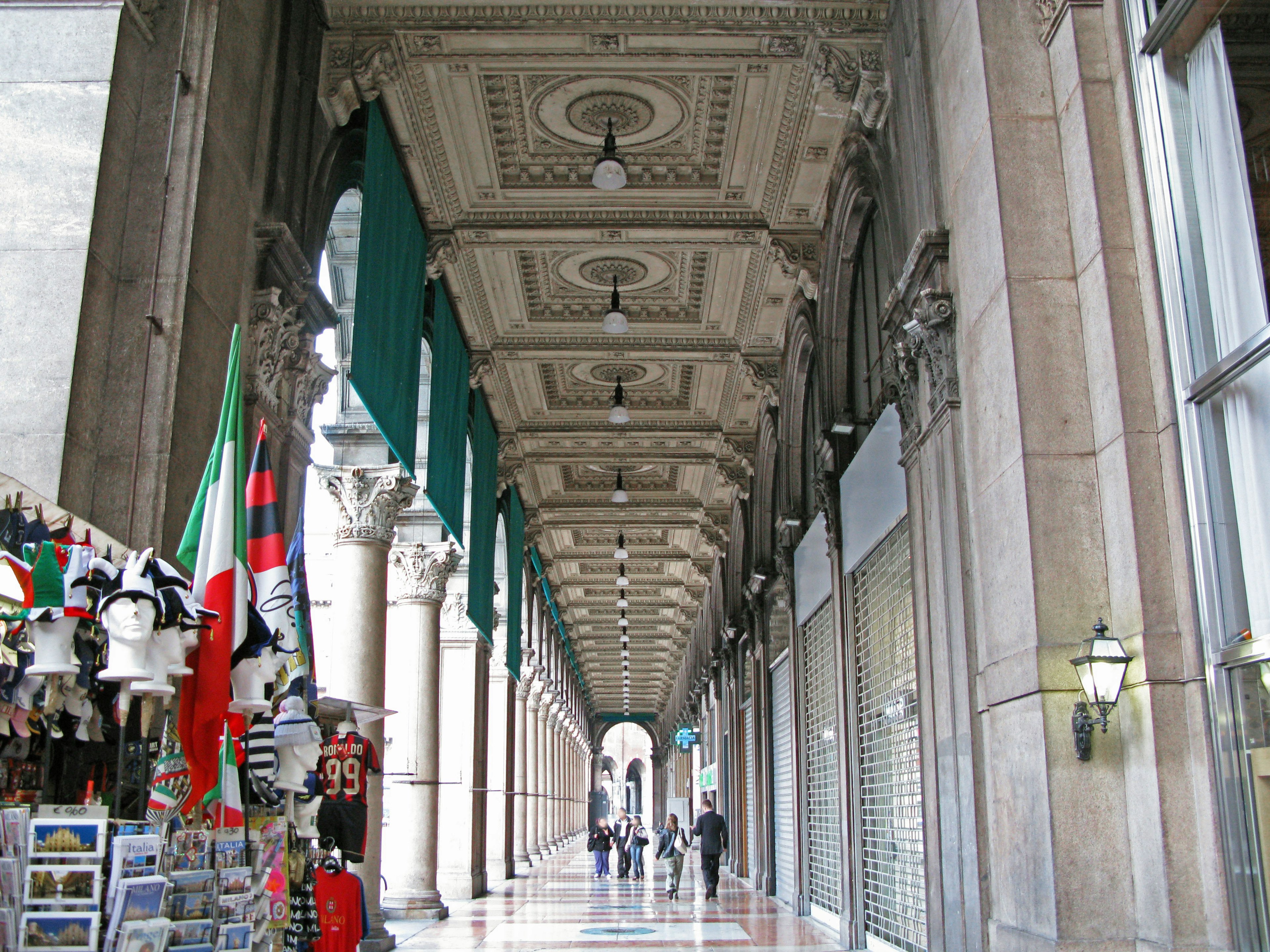 Plafond voûté et colonnes décoratives dans une galerie marchande avec des vitrines