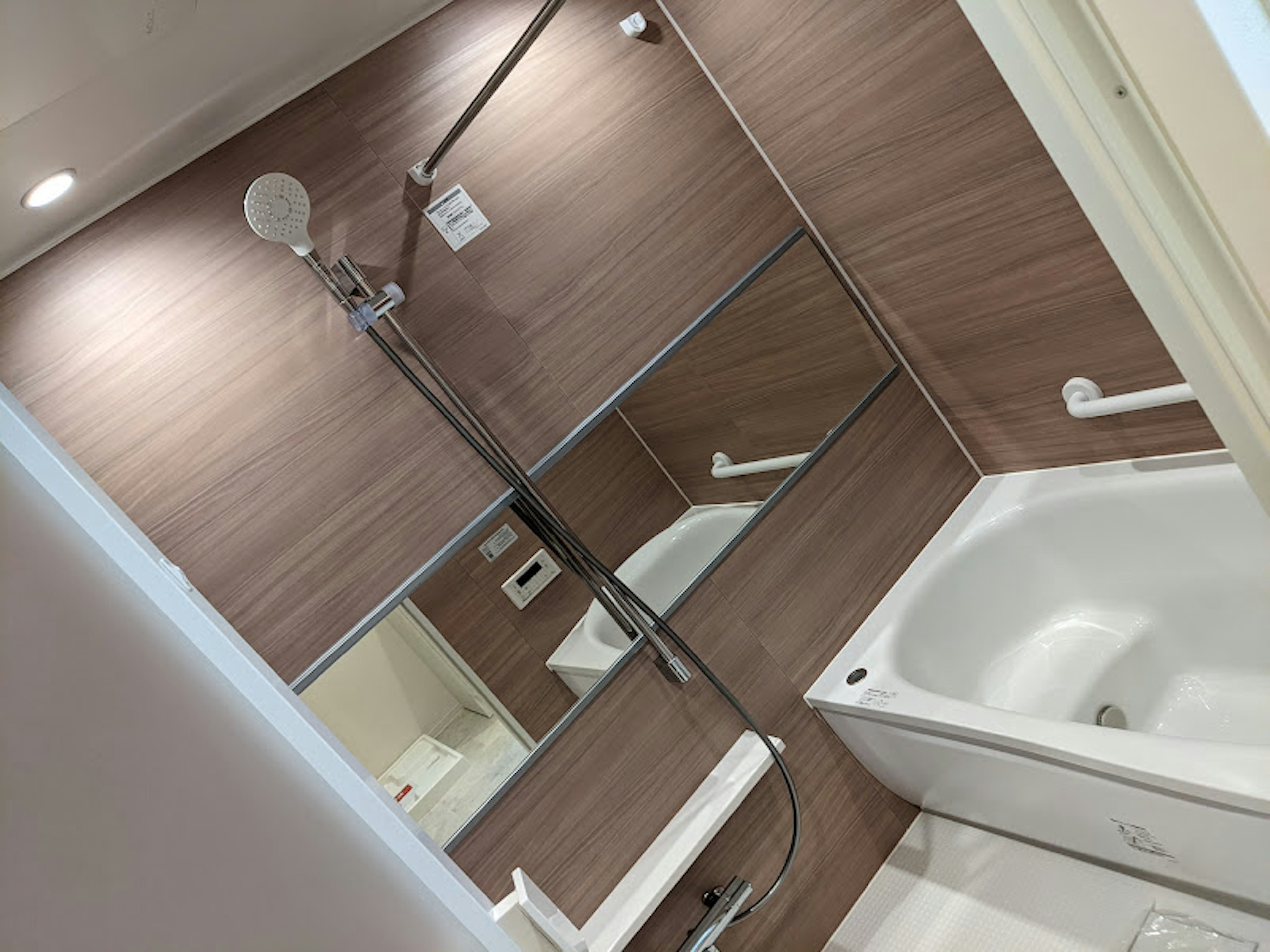 Design de salle de bain moderne avec des panneaux en bois brun douche et baignoire incluses