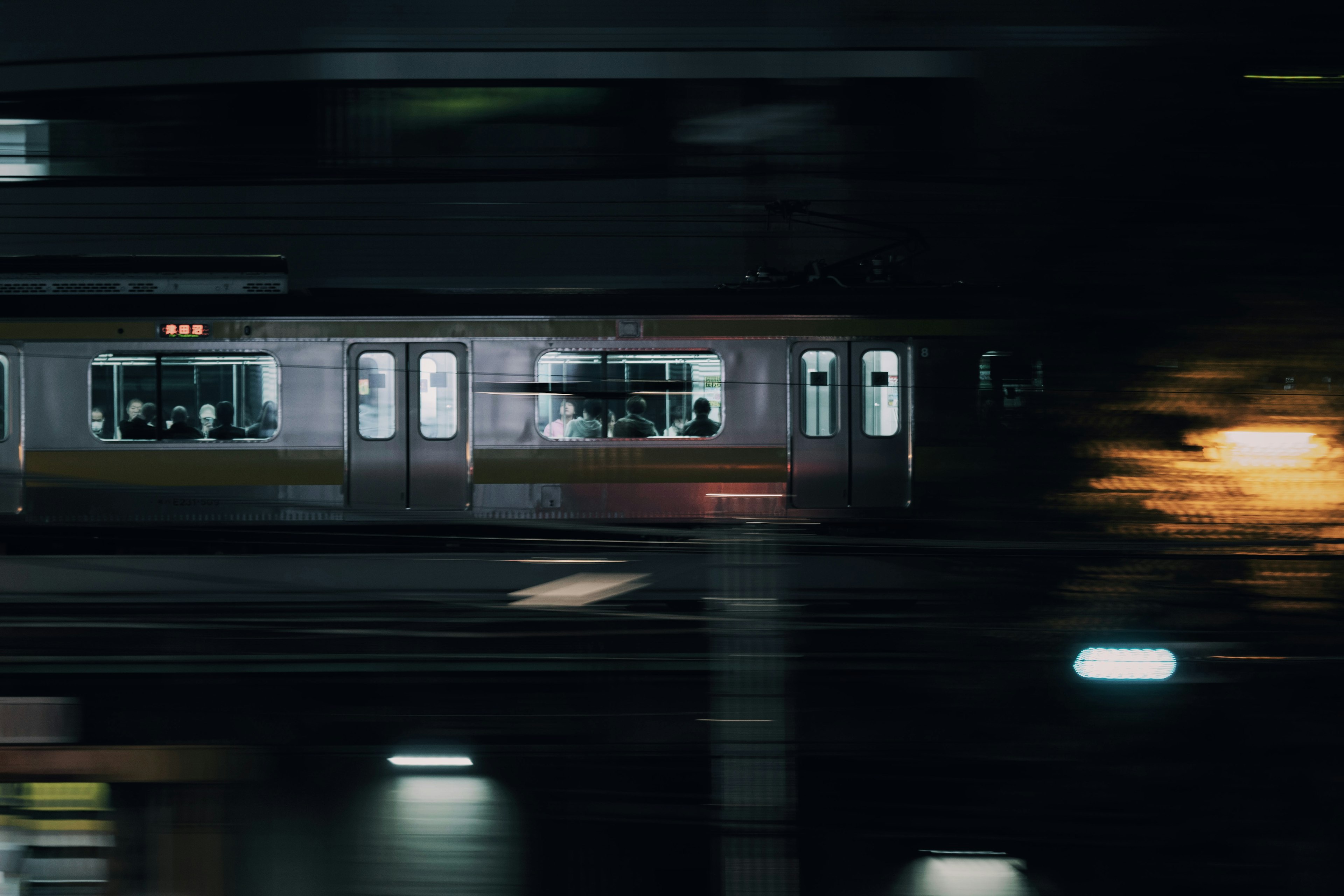 Immagine di un treno che si muove attraverso un paesaggio urbano notturno