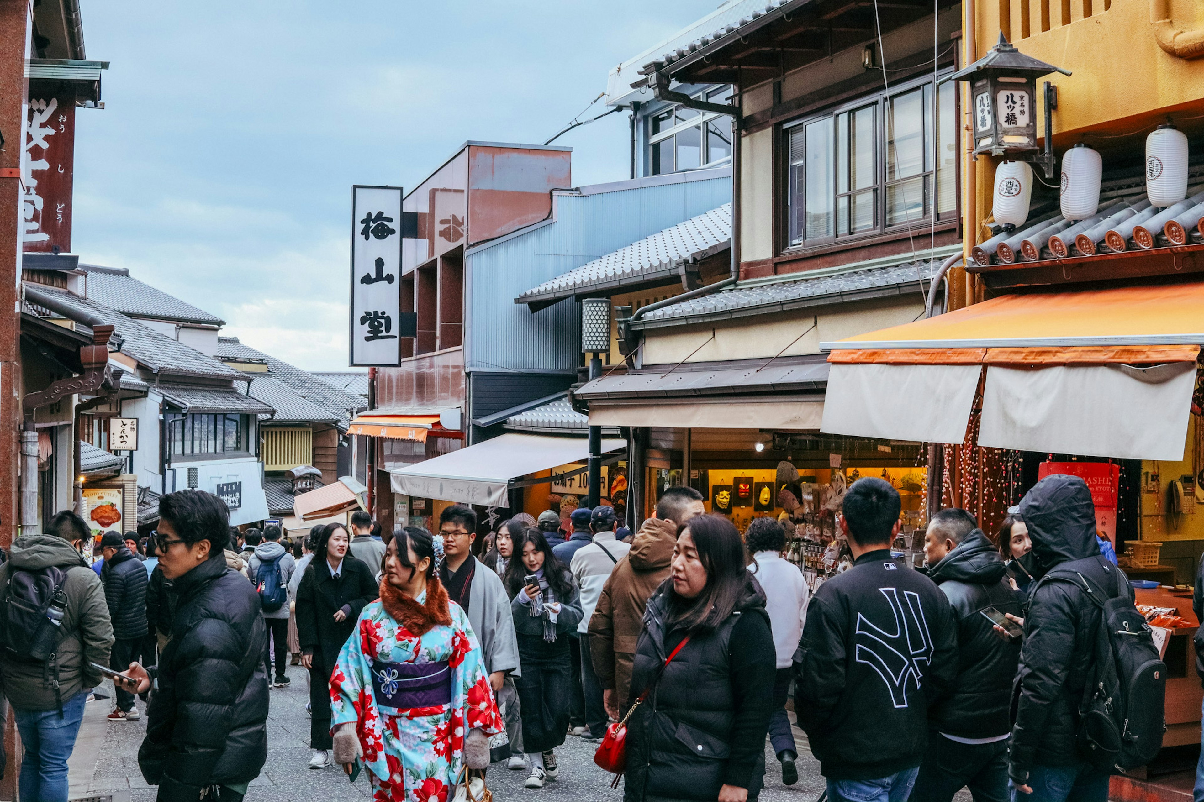 Bustling shopping street with a woman in a kimono walking