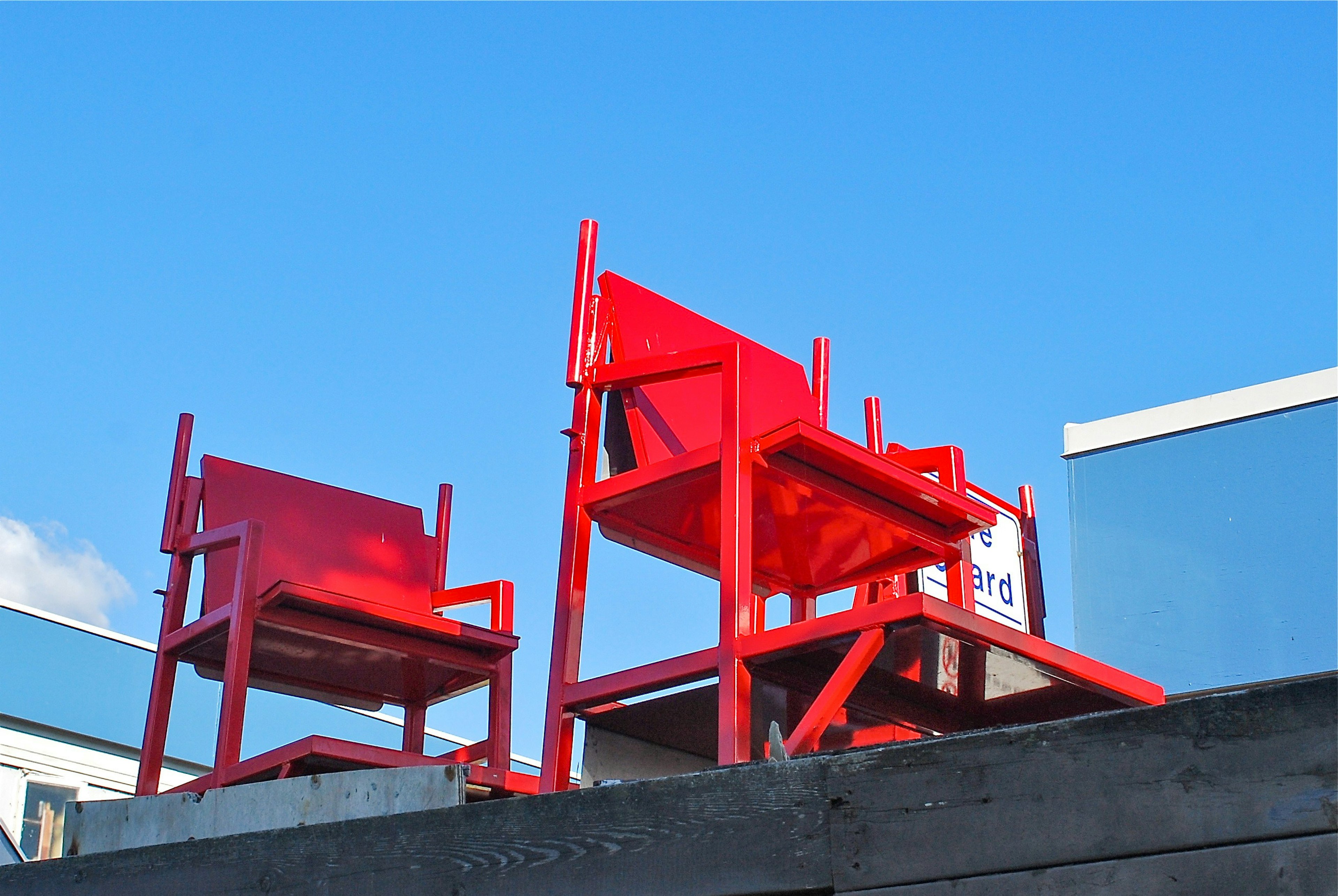 Sedie rosse impilate contro un cielo blu brillante