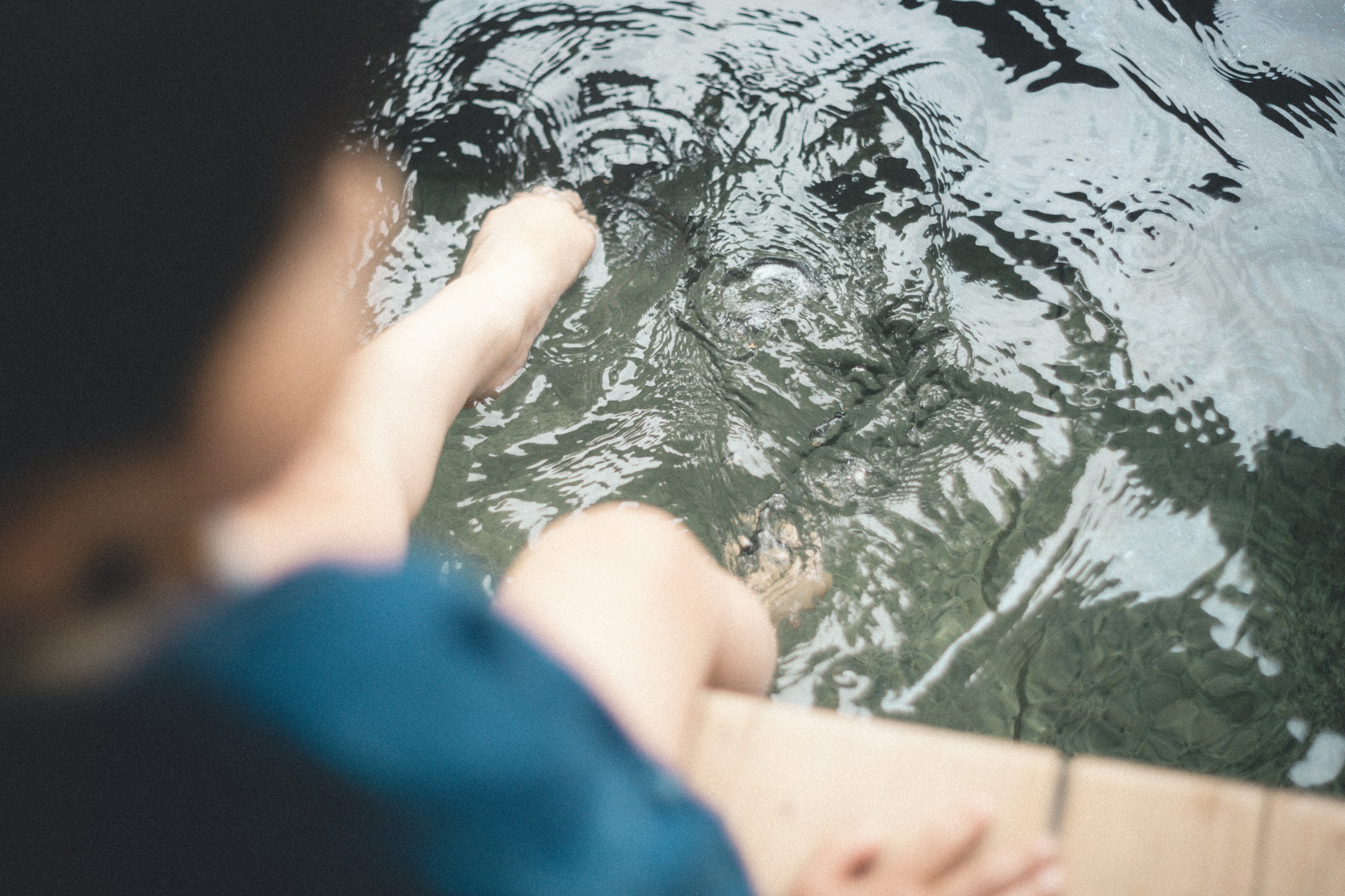 Person dipping feet in water with blurred background