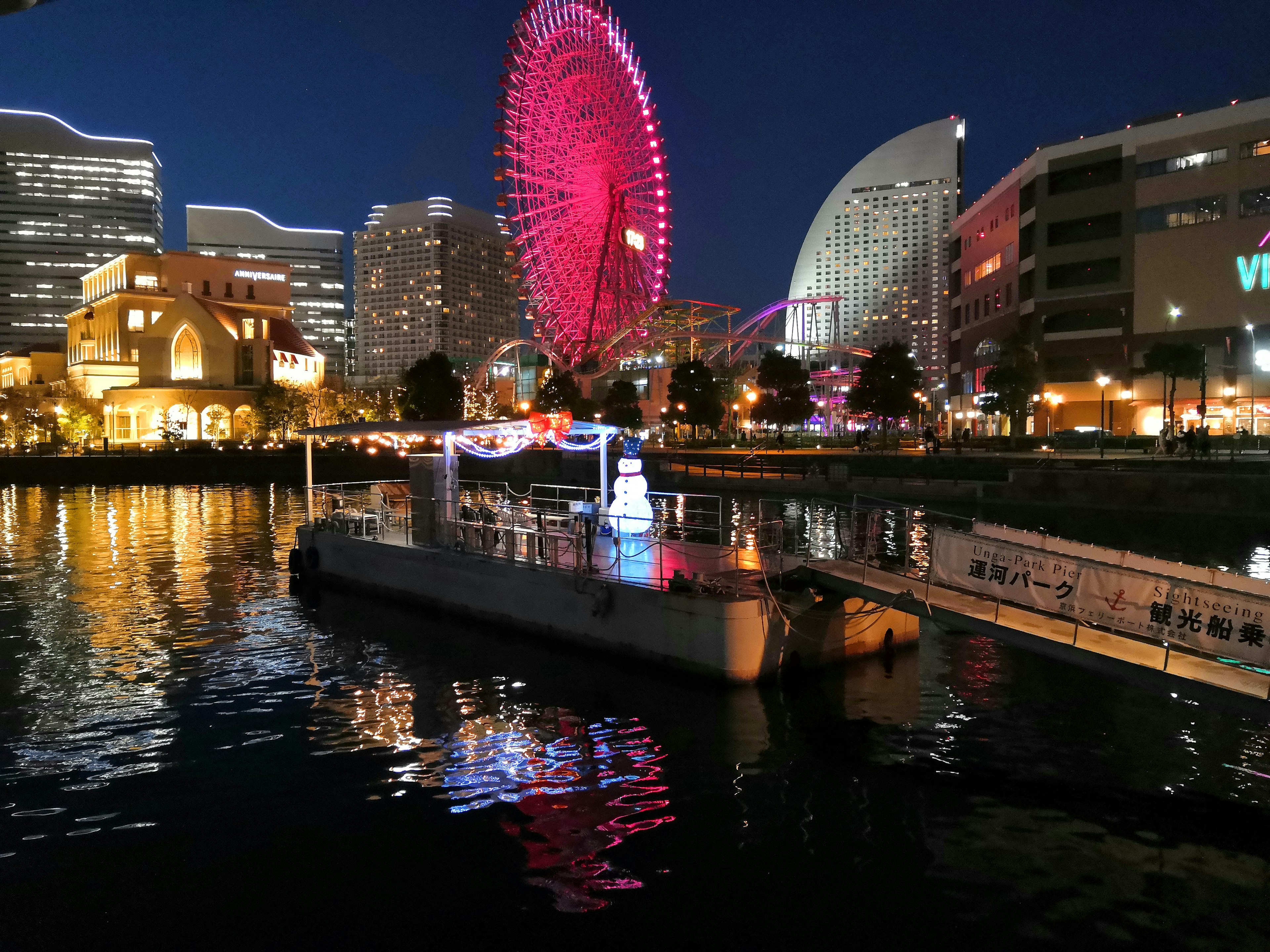 Pemandangan malam Yokohama dengan roda raksasa dan refleksi di air