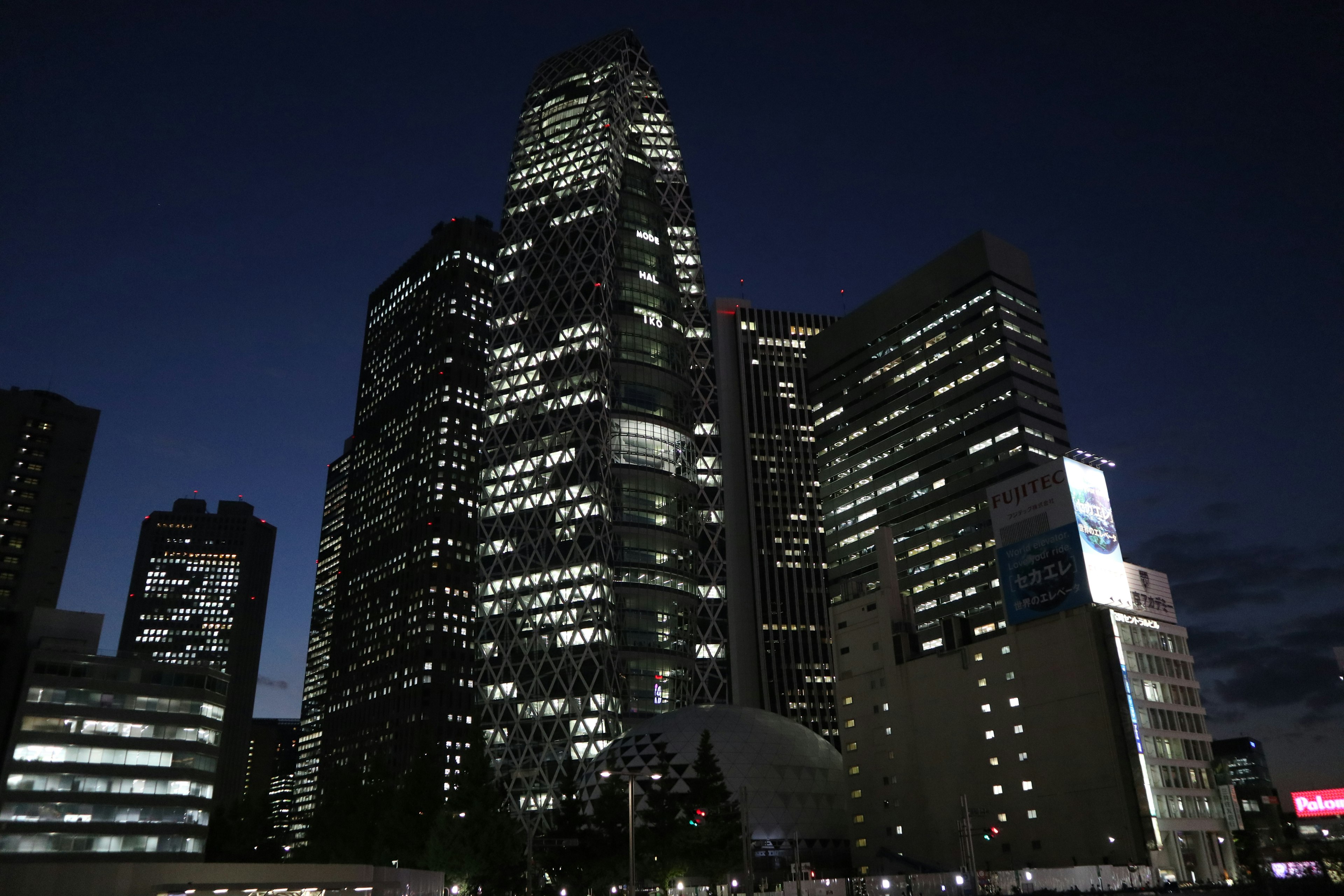 夜の都市景観にそびえる高層ビル群の明かり