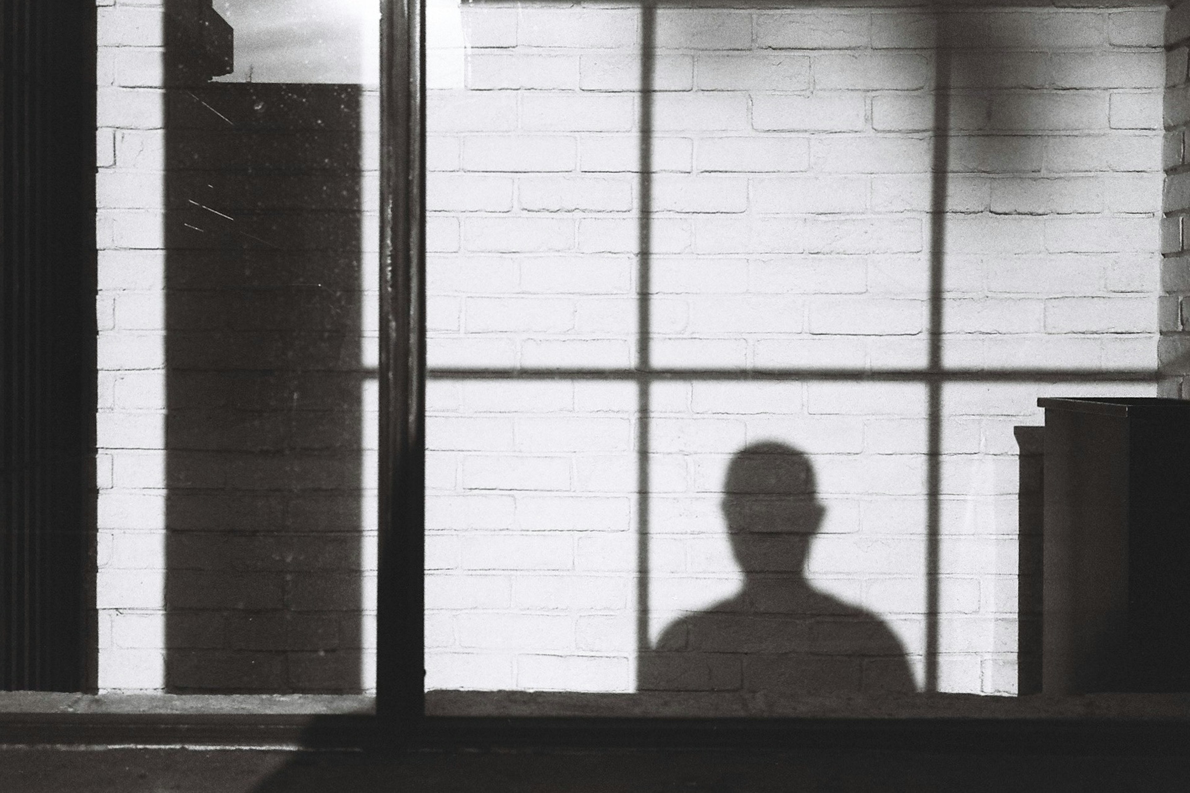 A simple composition featuring a person's shadow against a dimly lit background