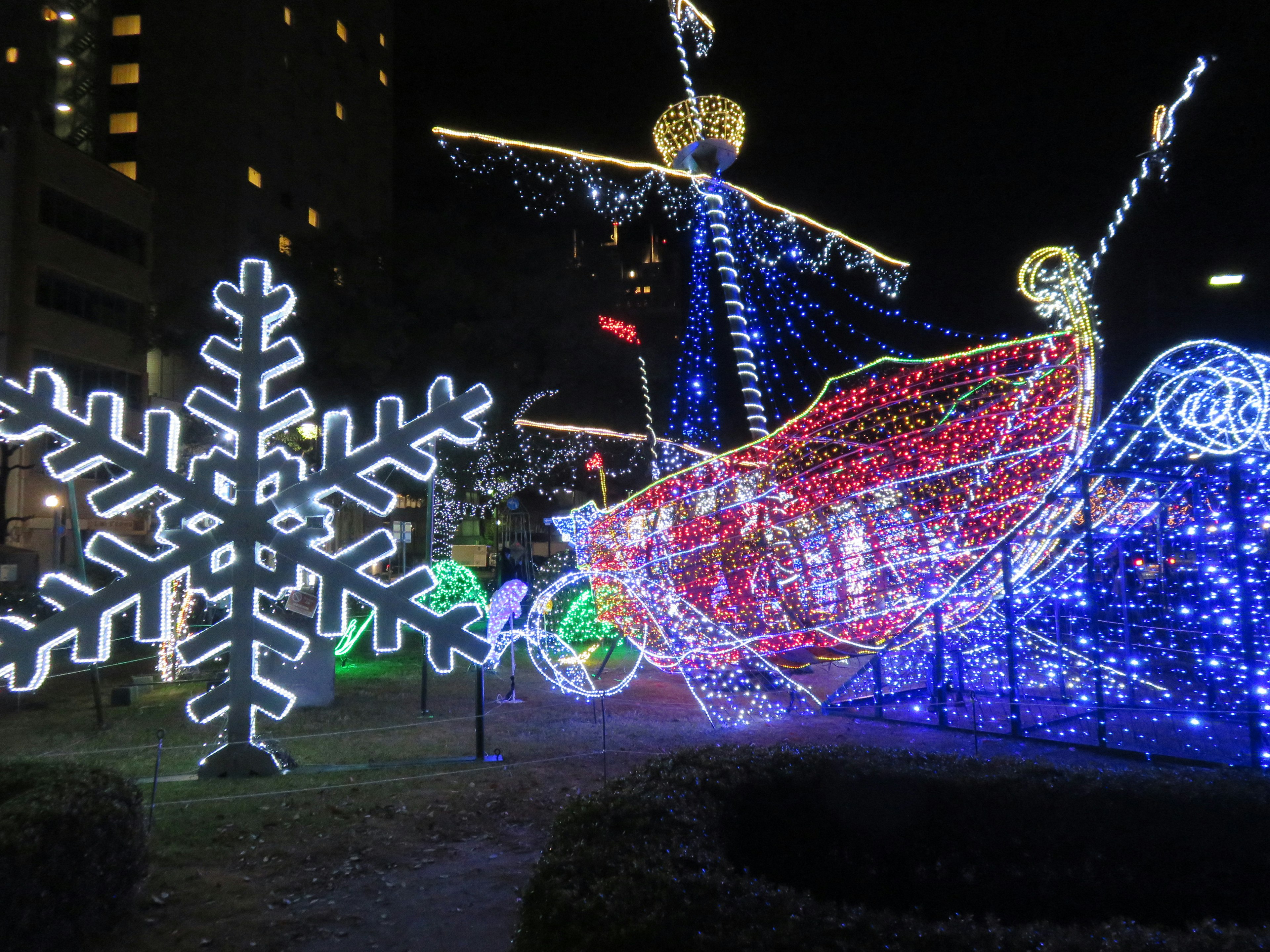 Illuminated ship and snowflake decoration at night