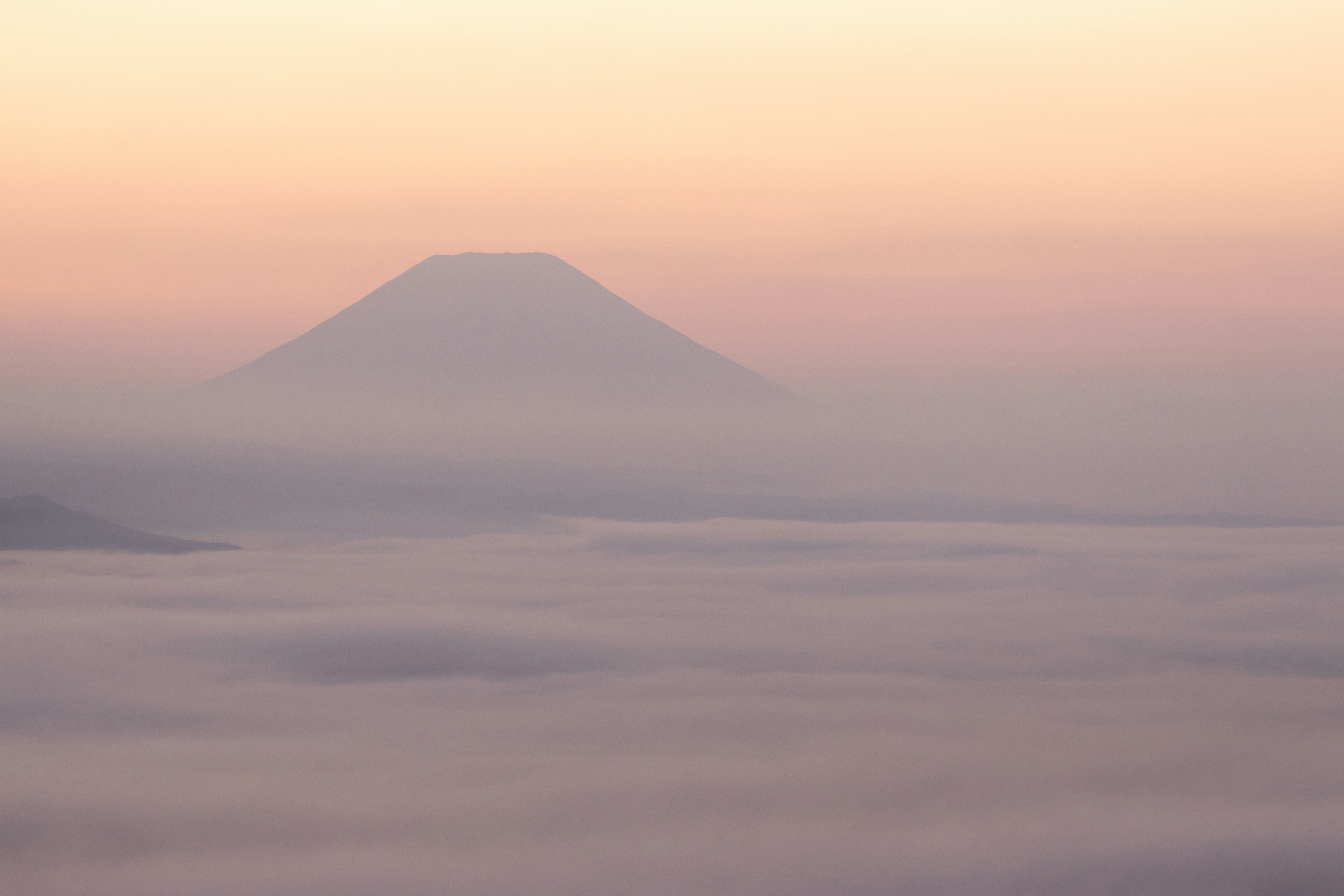 Silhouette des Mount Fuji in Nebel gehüllt mit sanftem Pastellhimmel