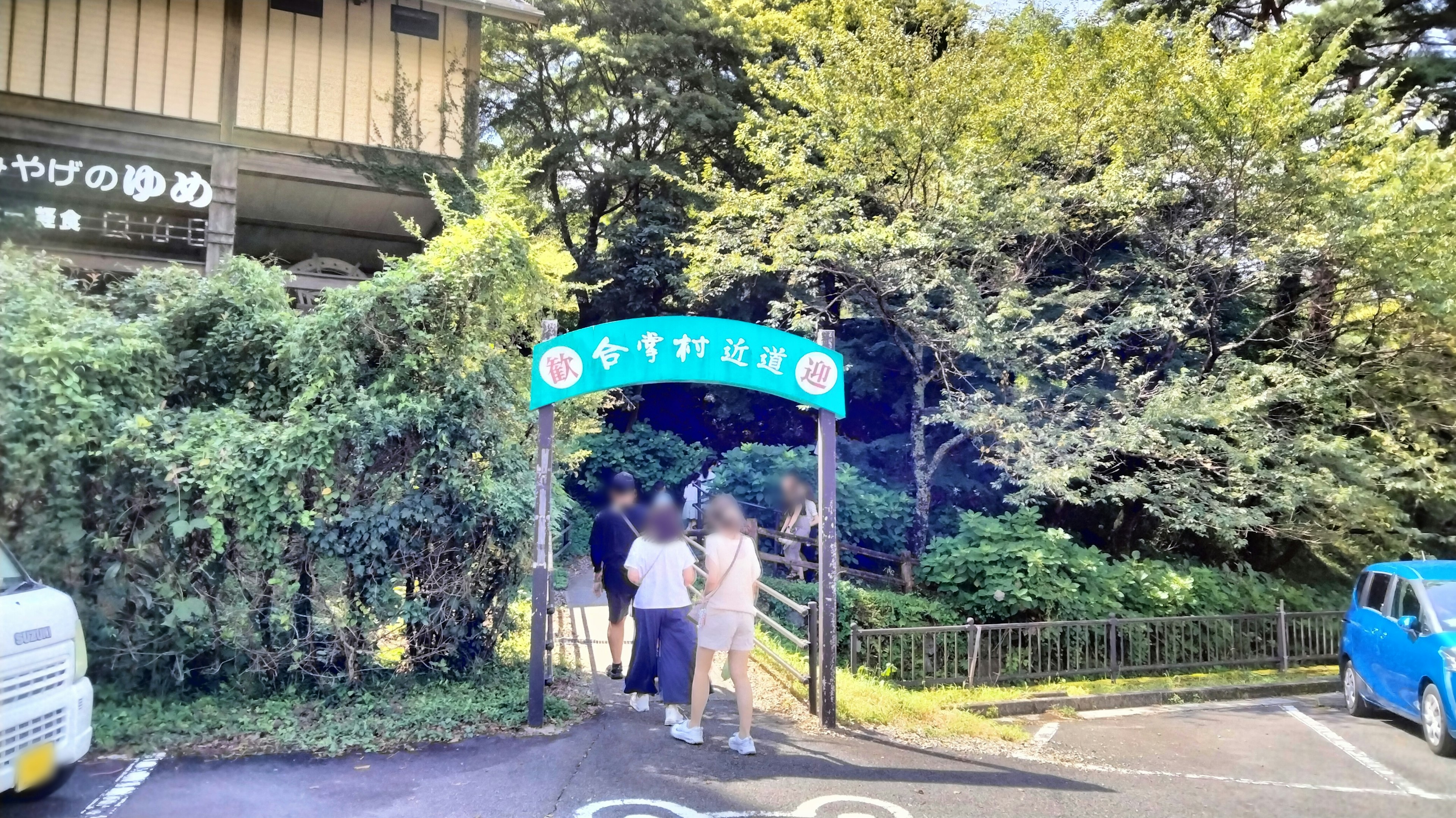 Entrée d'un parc entouré de verdure avec des gens rassemblés