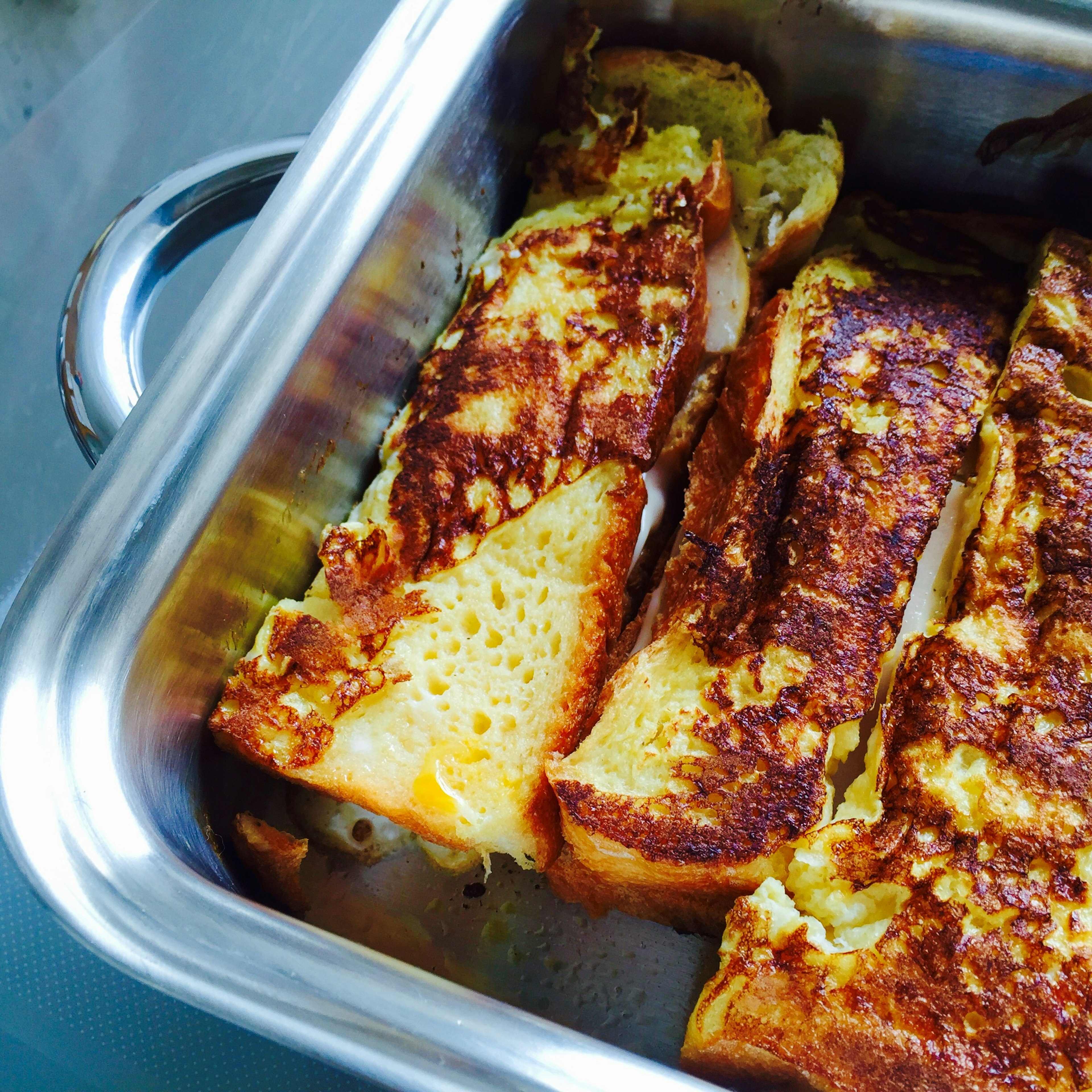 Sliced French toast with golden brown crust in a metal tray