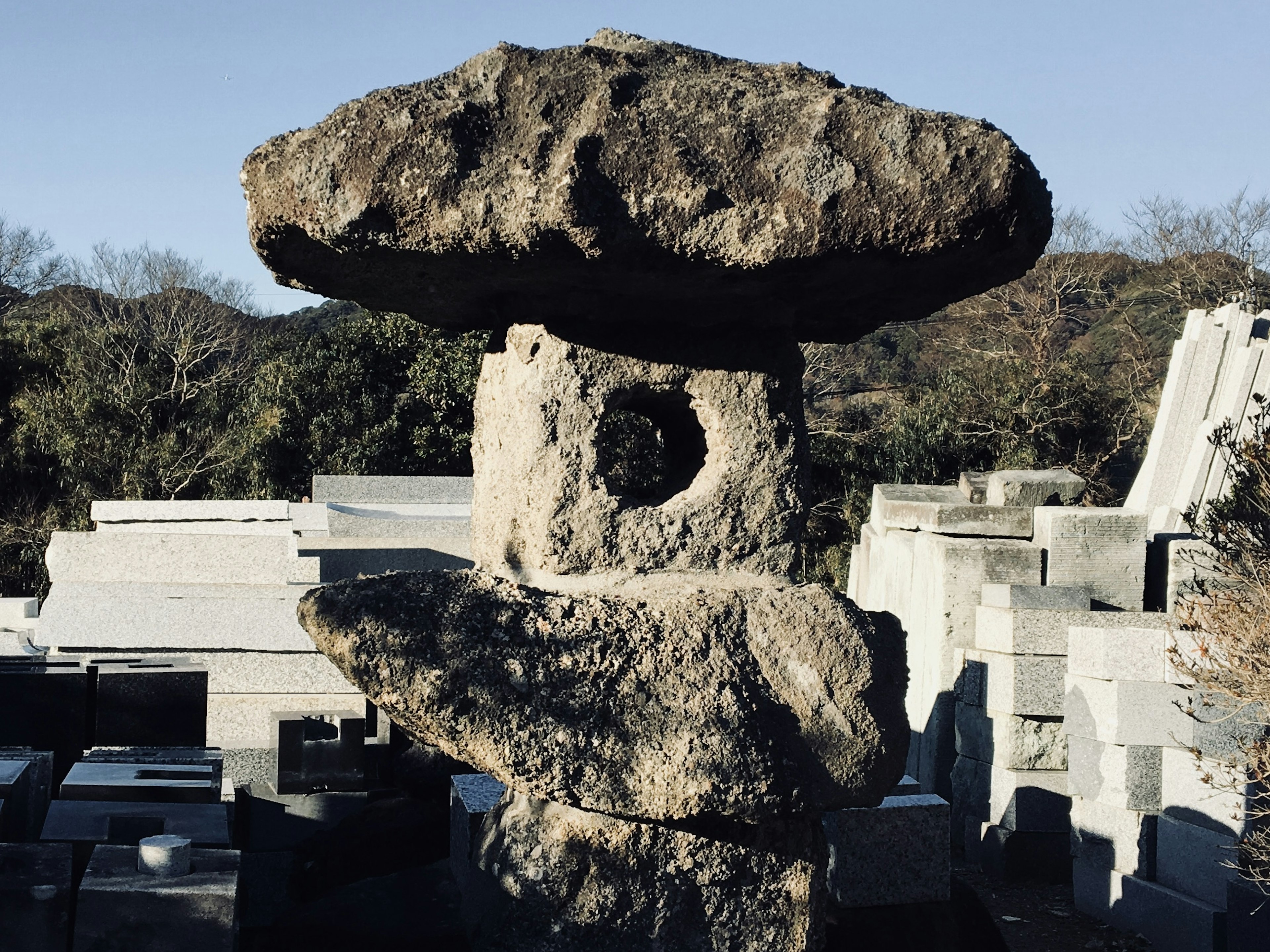 Une lanterne en pierre se tenant dans un cimetière